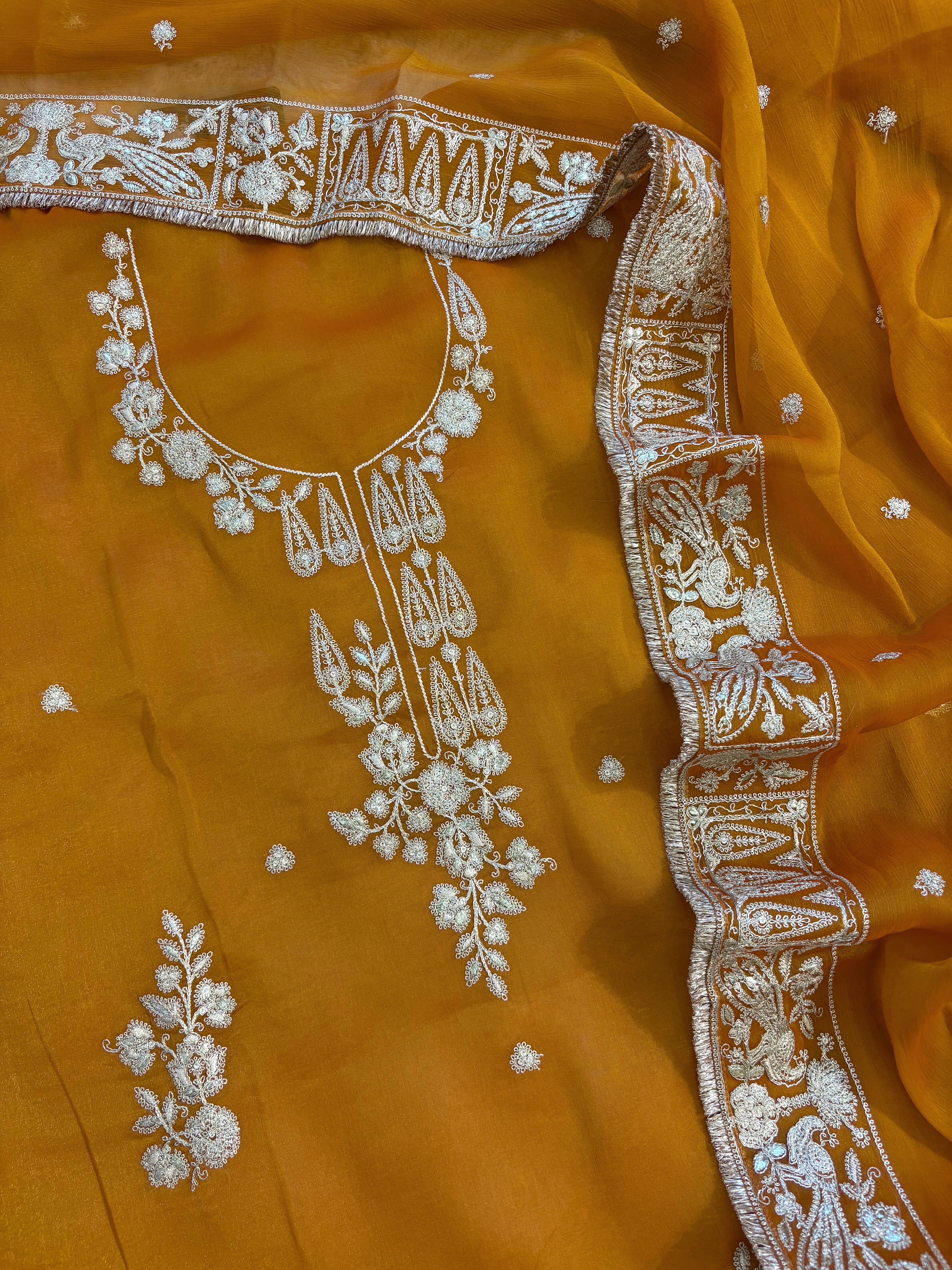 Mustard Yellow organza unstitched suit with golden zari embroidery and embroidered dupatta, ideal for weddings and festive celebrations.