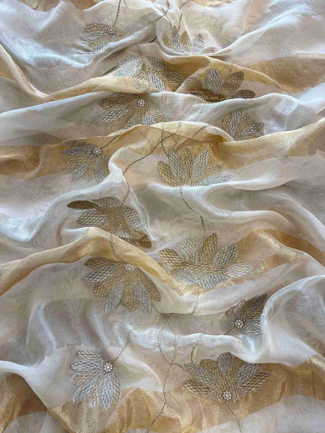 Thread work, cutdana and mirror work on the hemline of champagne beige shimmer organza suit