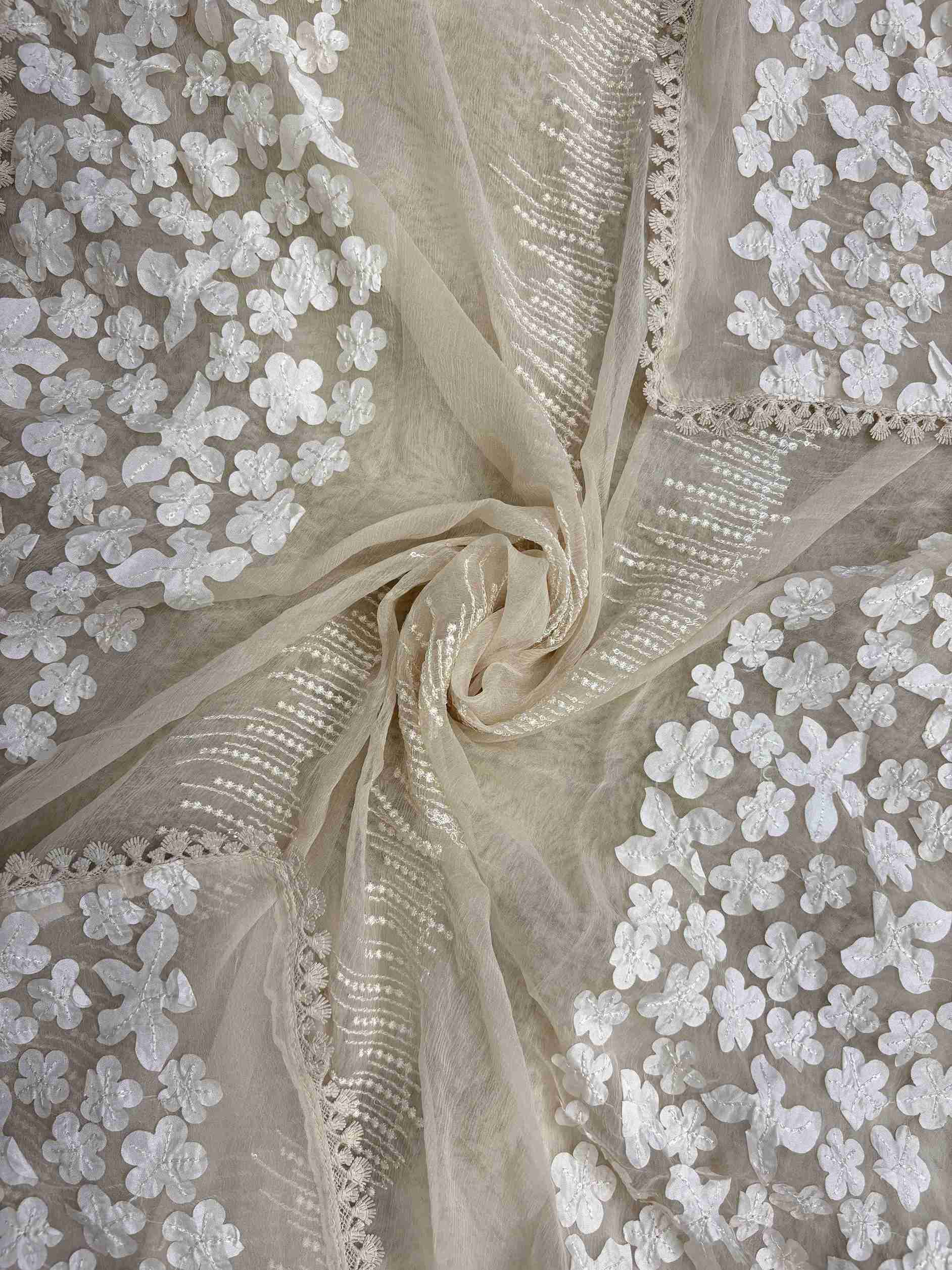 White floral applique on longer sides and four-sided lace finishing on champagne chiffon dupatta