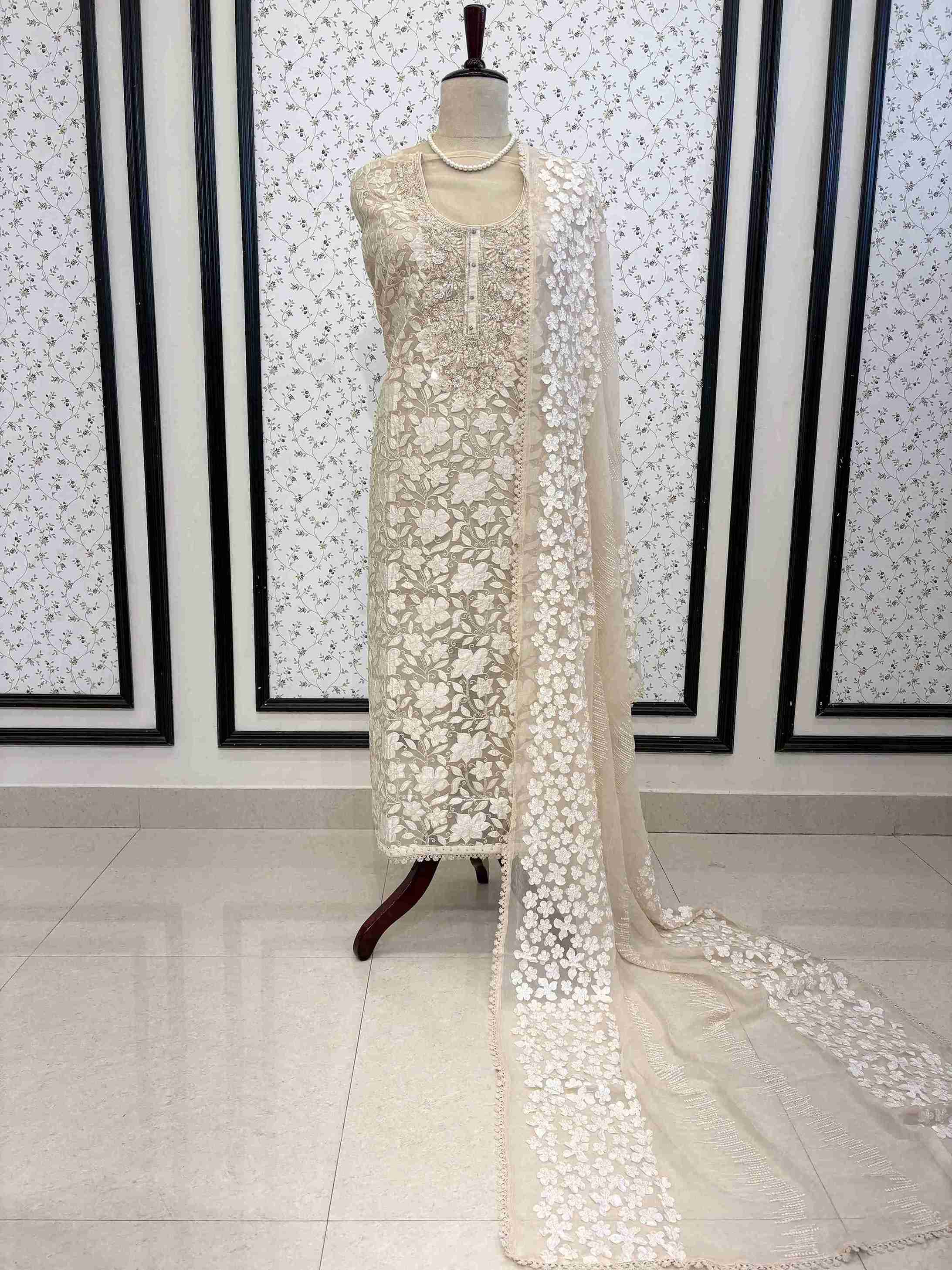 Champagne organza unstitched suit full front view with white floral applique and four-sided lace chiffon dupatta draped on mannequin