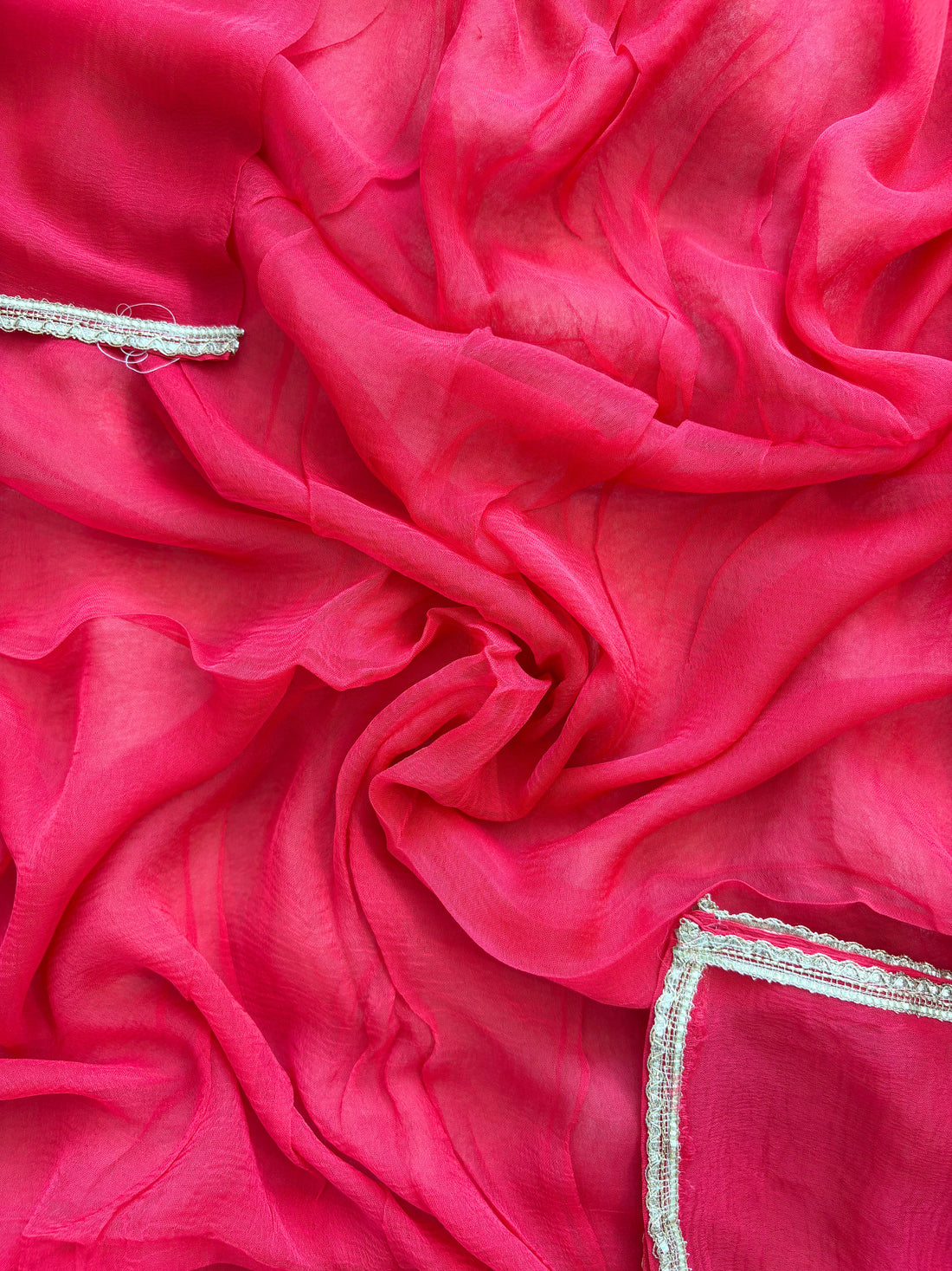 Red organza bandhani suit with ombre effect and chiffon dupatta with lace border.