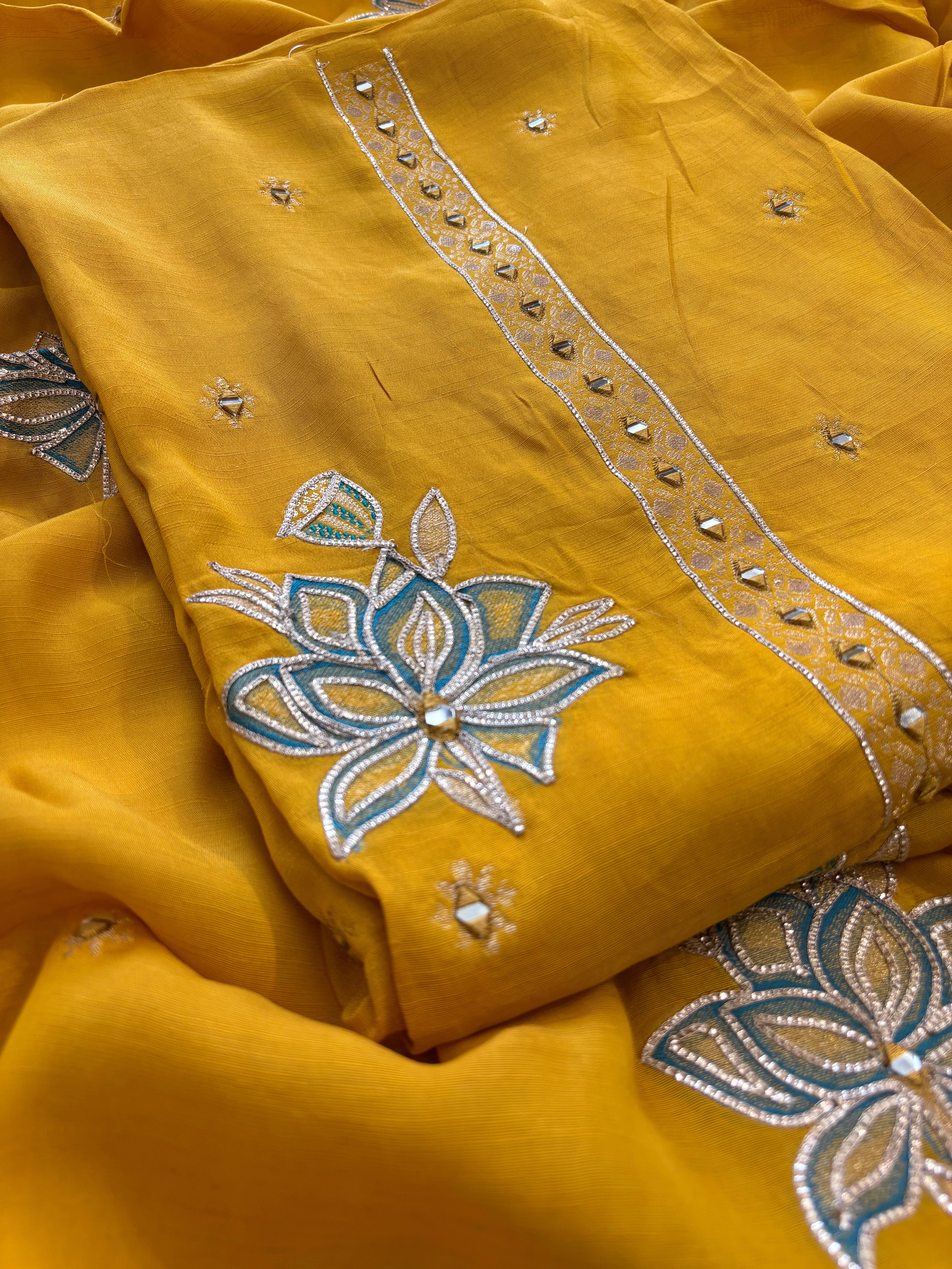Mustard yellow linen suit with mirror work embroidery and applique floral dupatta.