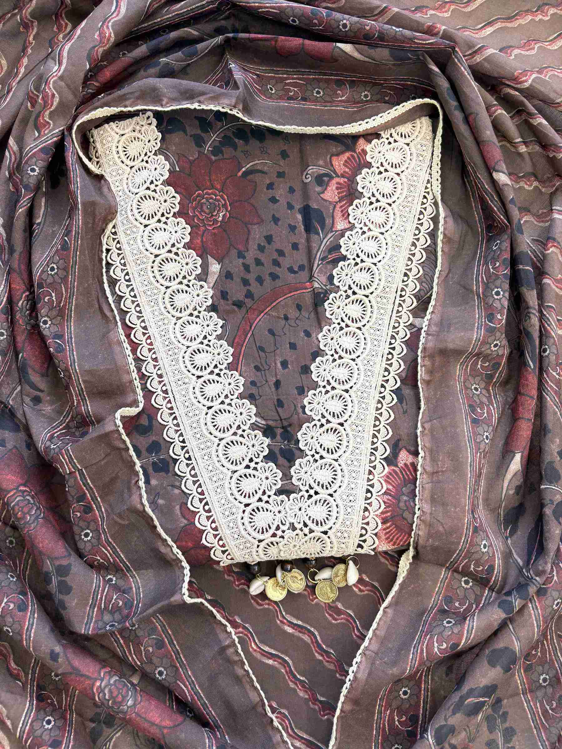 Close-up of all-over digital floral print with red blooms, paisleys and botanical motifs on dark chocolate brown cotton shirt body
