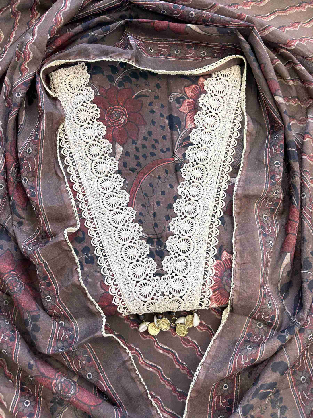 Close-up of all-over digital floral print with red blooms, paisleys and botanical motifs on dark chocolate brown cotton shirt body