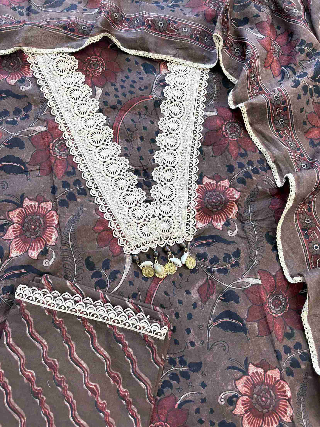 Complete dark chocolate brown cotton unstitched suit flat lay set with floral printed shirt, dupatta, and wave stripe printed bottom