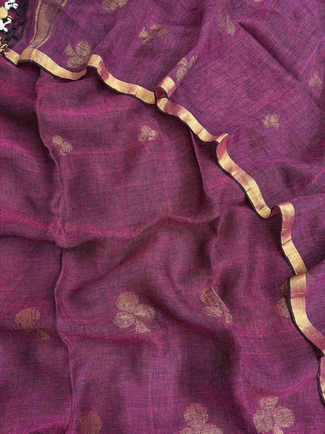 Scattered golden geometric spade woven motifs across deep magenta pure handloom linen dupatta surface