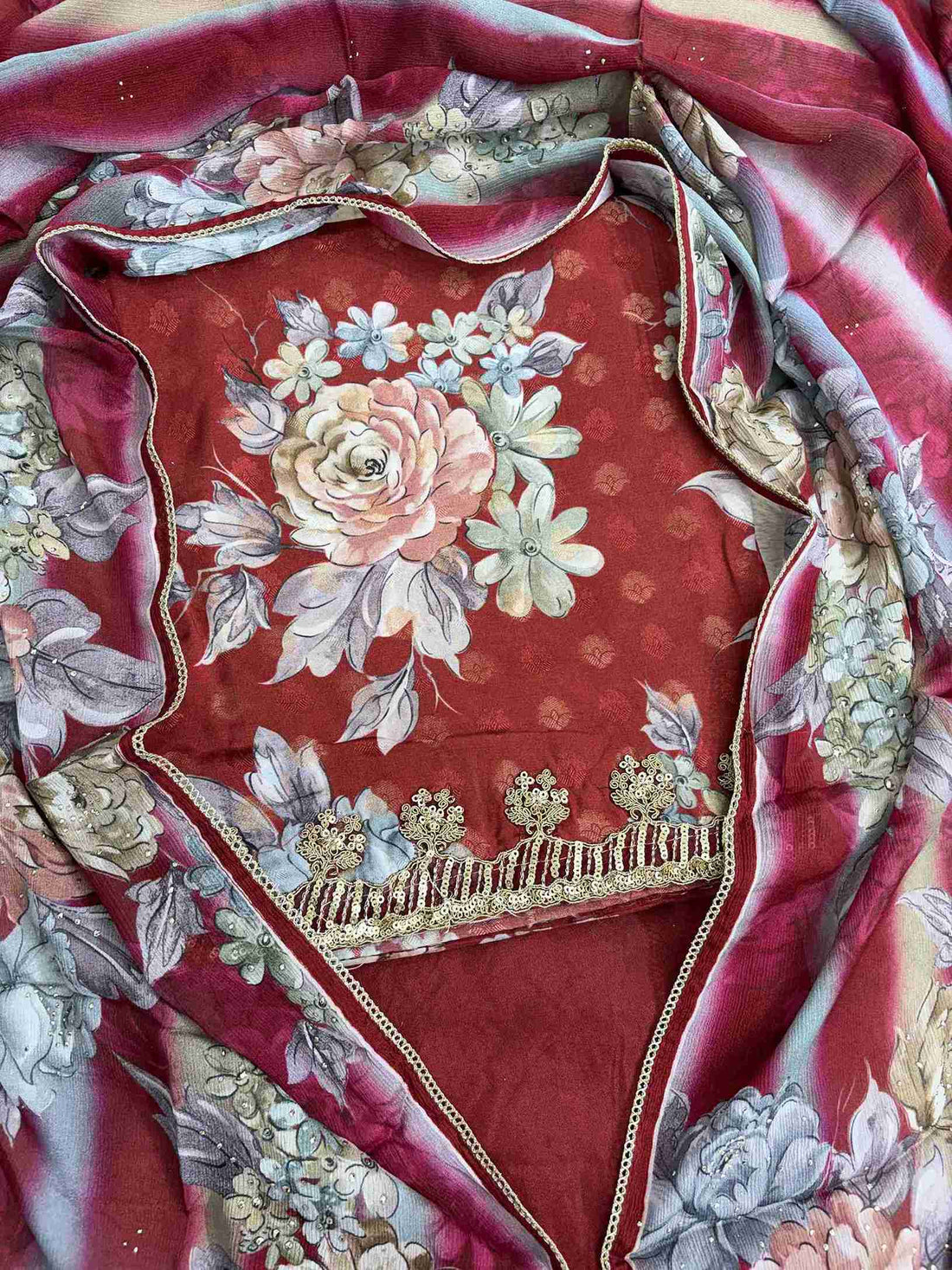 Close-up of all-over digital floral print in contrasting colors on deep red muslin shirt