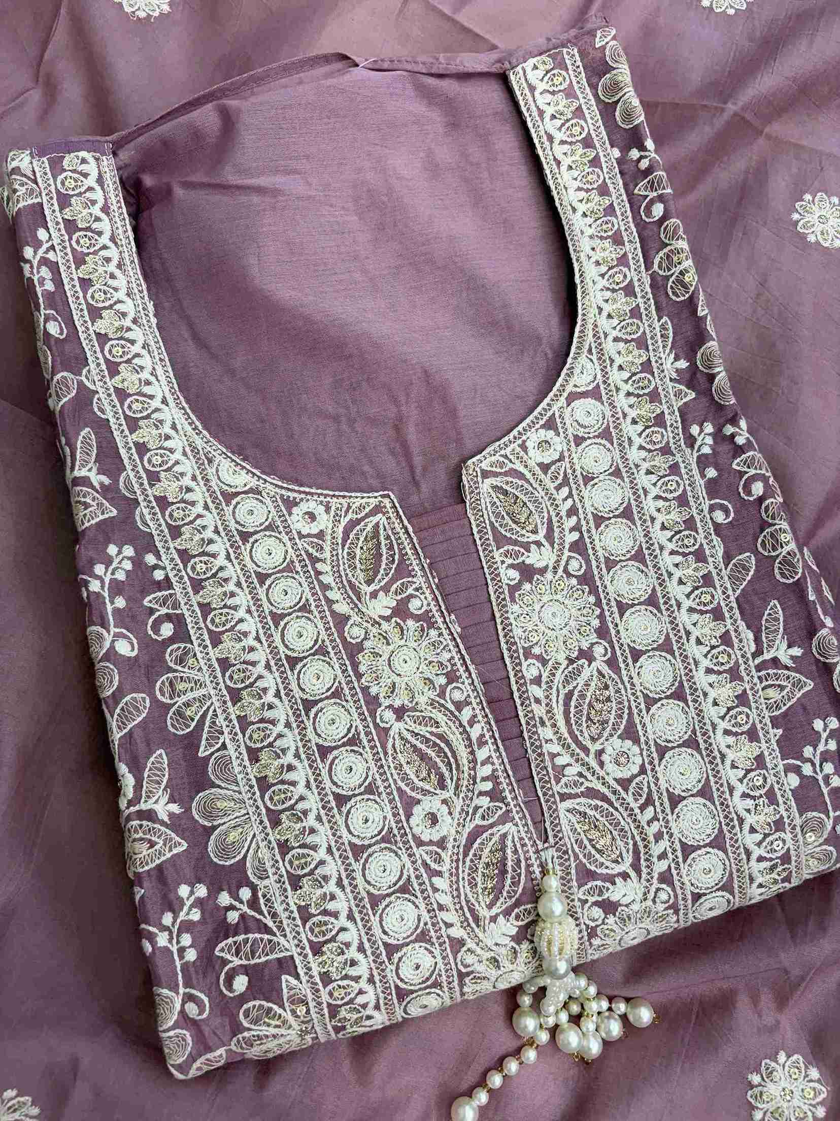 Close-up of U neckline with deep V cut and tassels on dusted mauve embroidered suit