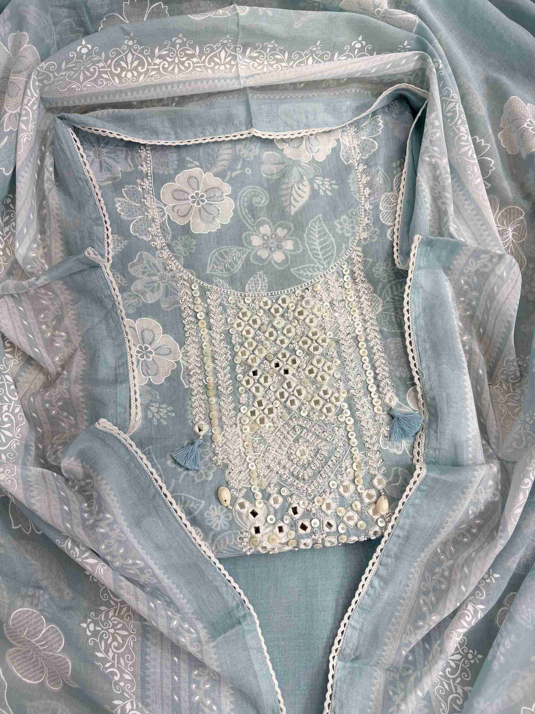 All-over white floral texture print detail across dusty blue cotton shirt body