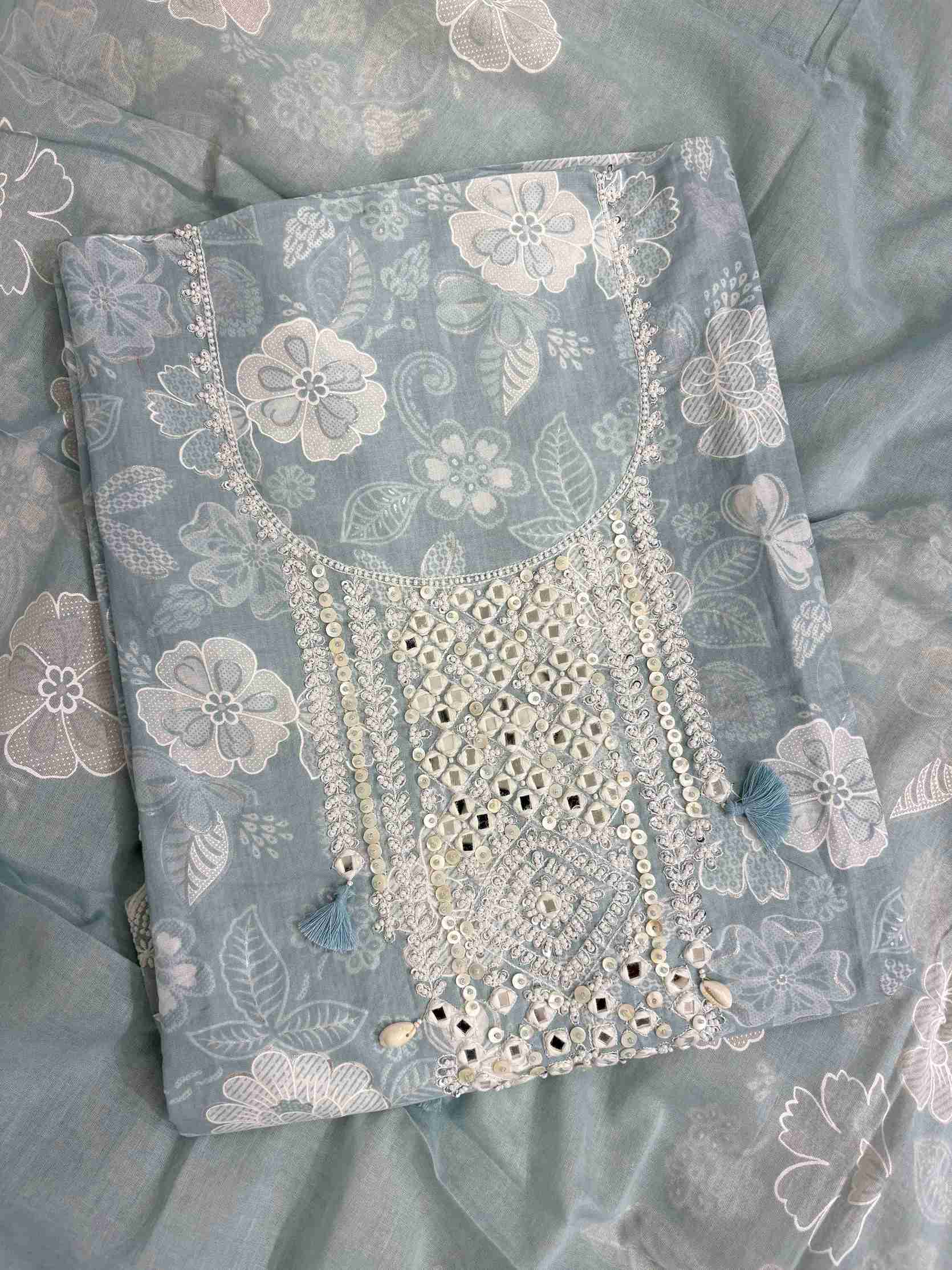 Close-up of mirror work, sequin and moti embellished neckline panel with tassels on dusty blue cotton shirt