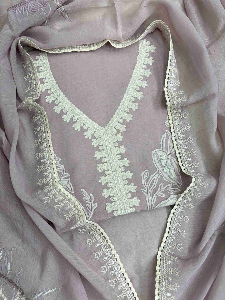 Large-scale white floral applique arrangement with botanical blooms and leaves on dusty rose mauve mul cotton shirt front