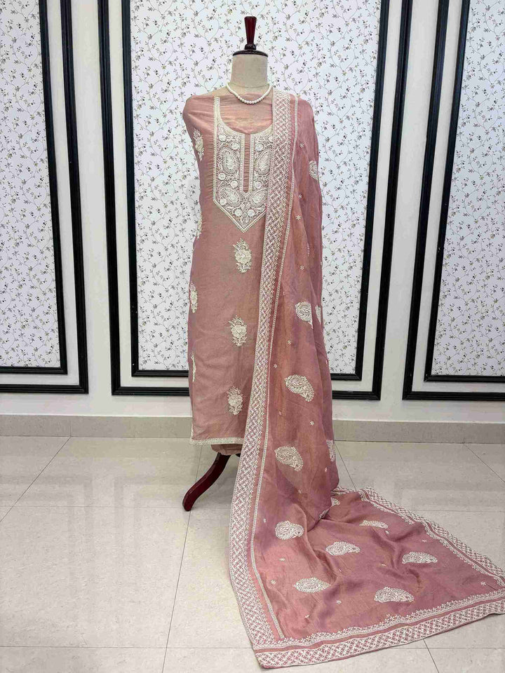 Dusty rose shimmer tissue unstitched suit with white chikankari inspired thread embroidery displayed on mannequin