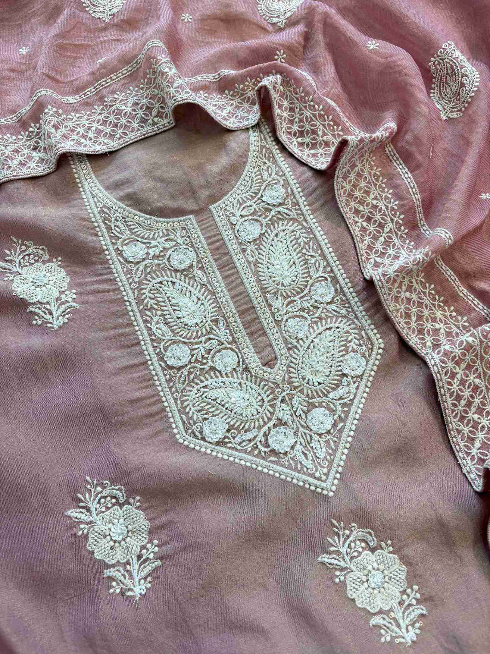 Close-up of white thread chikankari style embroidery on dusty rose shimmer tissue kurta fabric