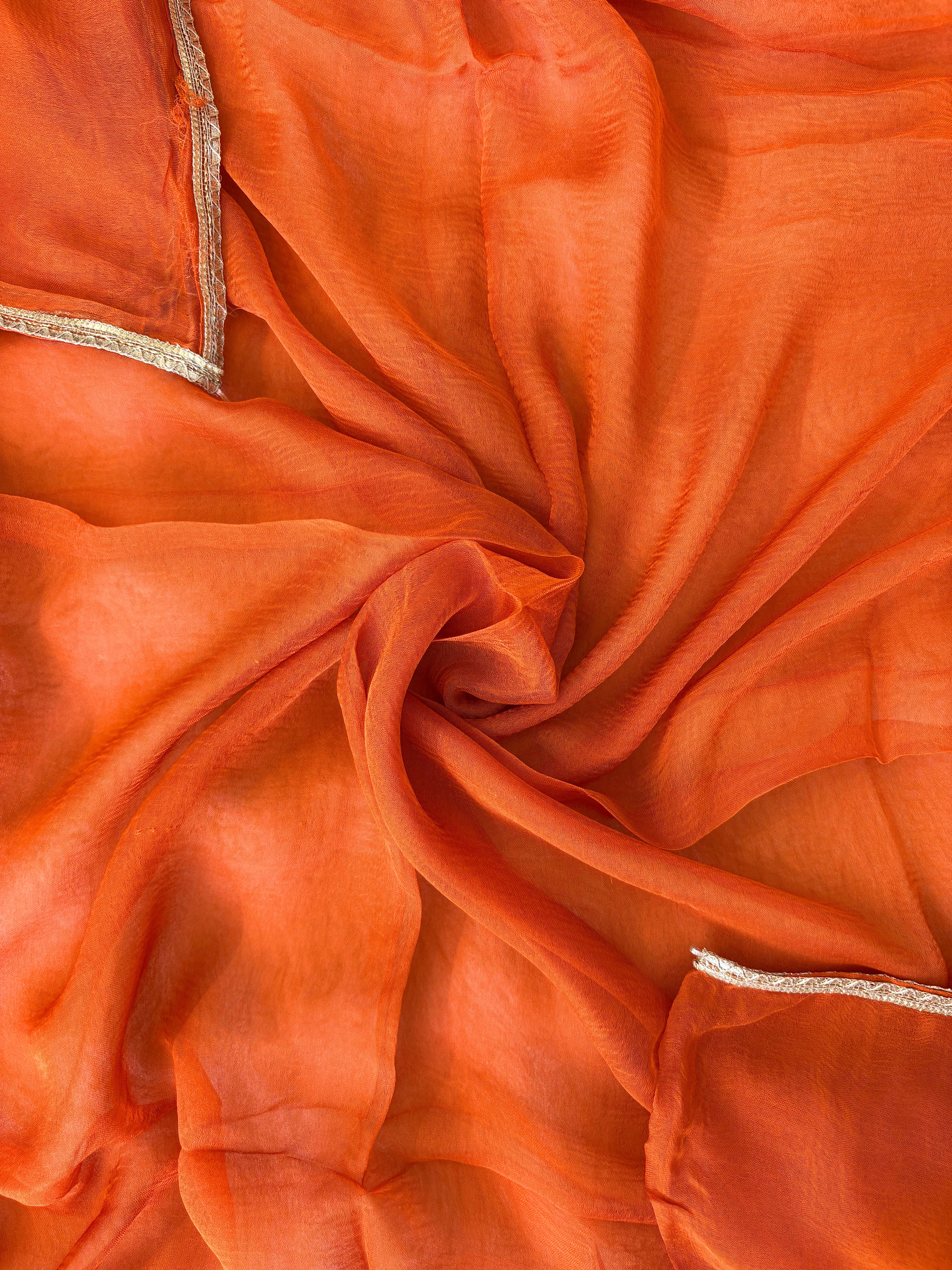 Orange Shimmer organza bandhani suit with ombre effect and chiffon dupatta with lace border.
