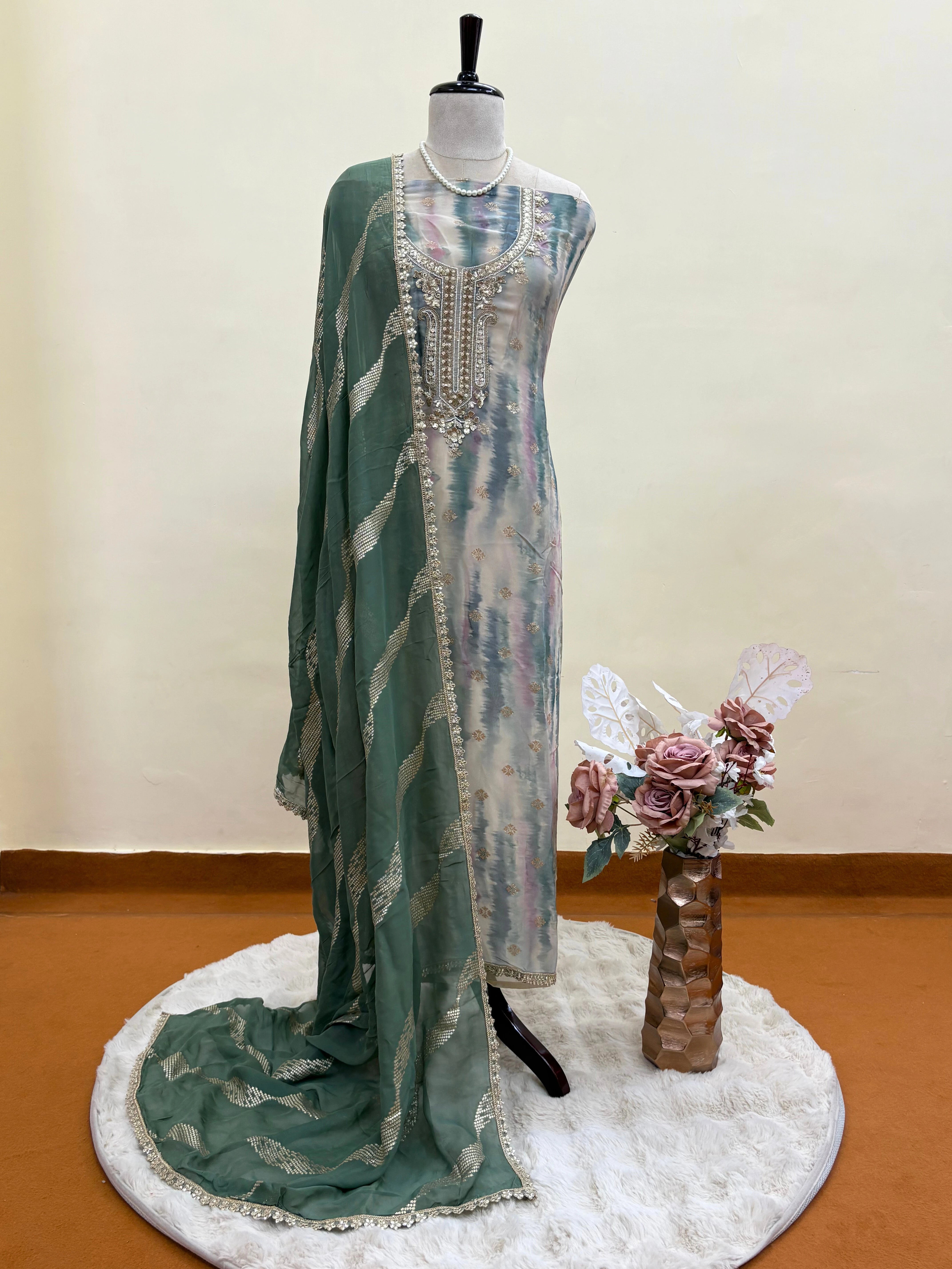 Pastel green organza suit with silver zari embroidery, pearl embellishments, and sequin work, paired with an banarisi jacquard dupatta for weddings and festive occasions.