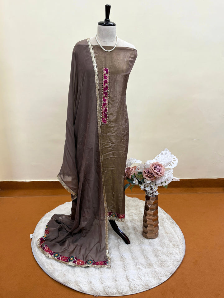 Taupe brown organza unstitched suit with mirror work, sequin embroidery, and magenta contrast neckline patch, paired with mirror lace organza dupatta – festive ethnic wear