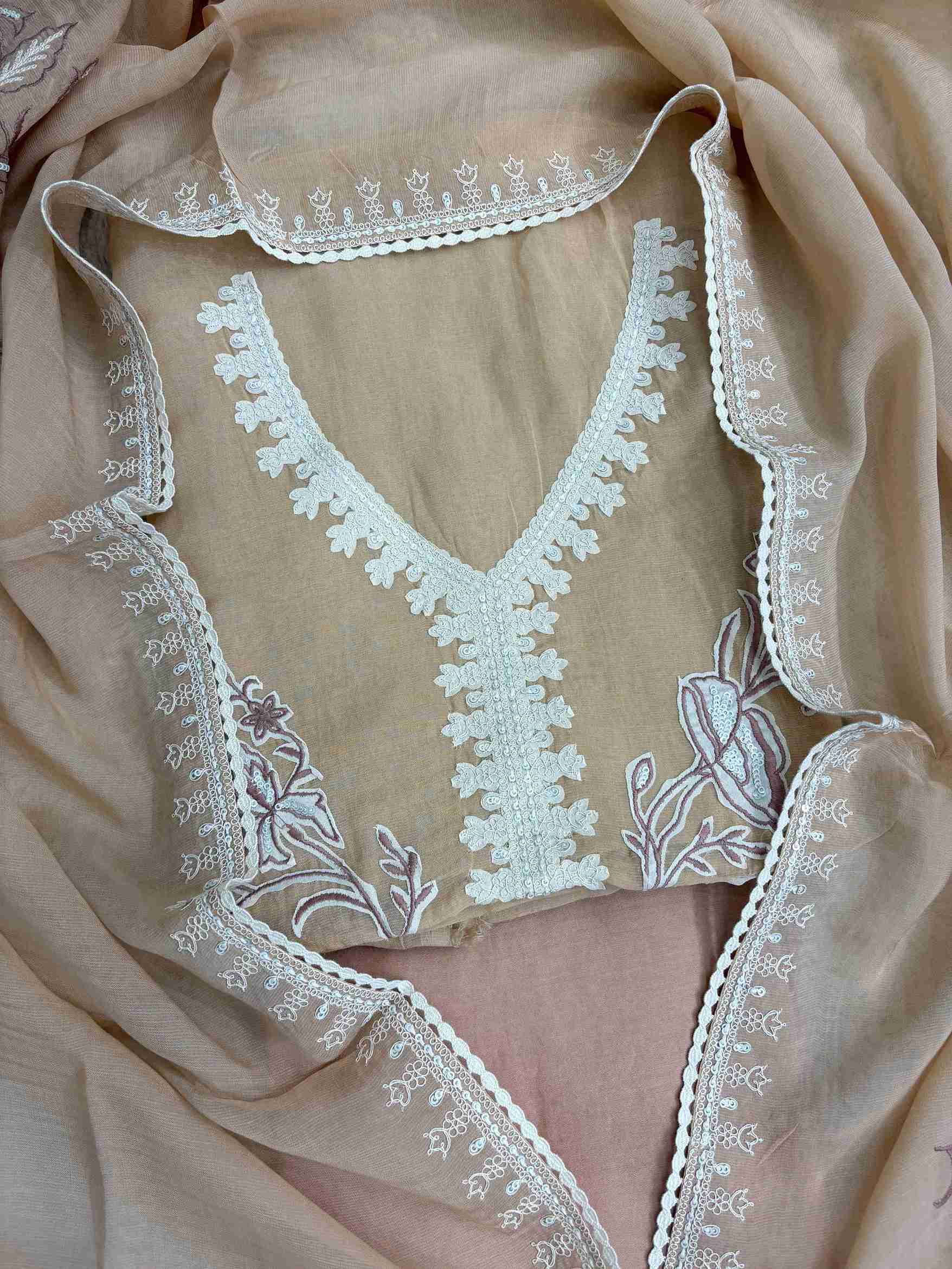 Large-scale white floral applique arrangement with botanical blooms and leaves on peach mul cotton shirt front