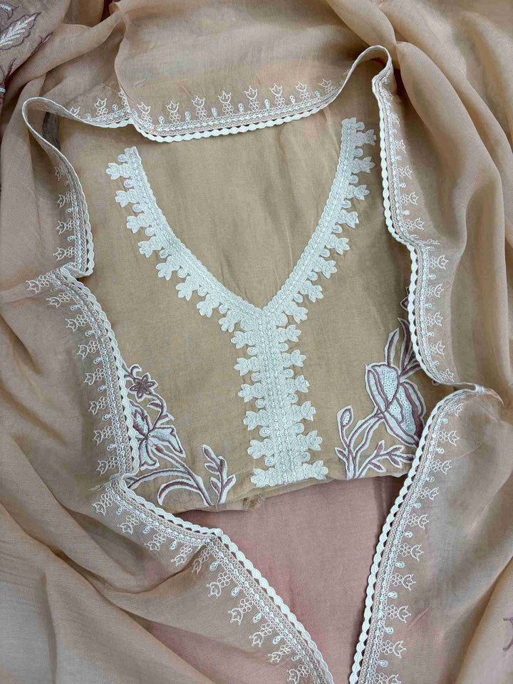 Large-scale white floral applique arrangement with botanical blooms and leaves on peach mul cotton shirt front