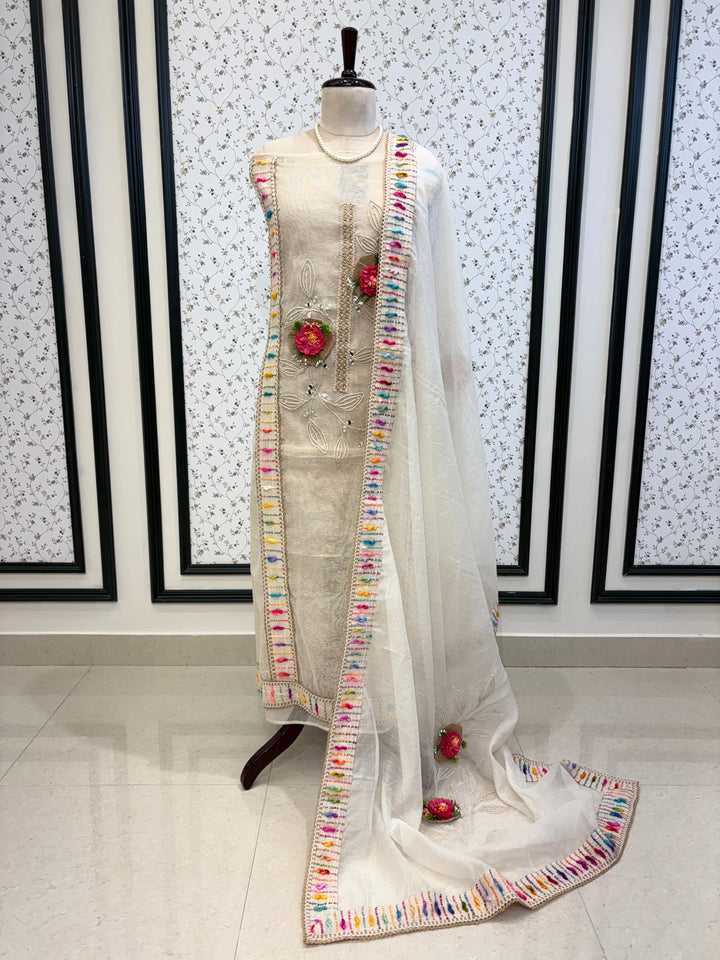 Ivory jute cotton suit with 3D floral embellishments and embroidered dupatta with multicolor thread border.