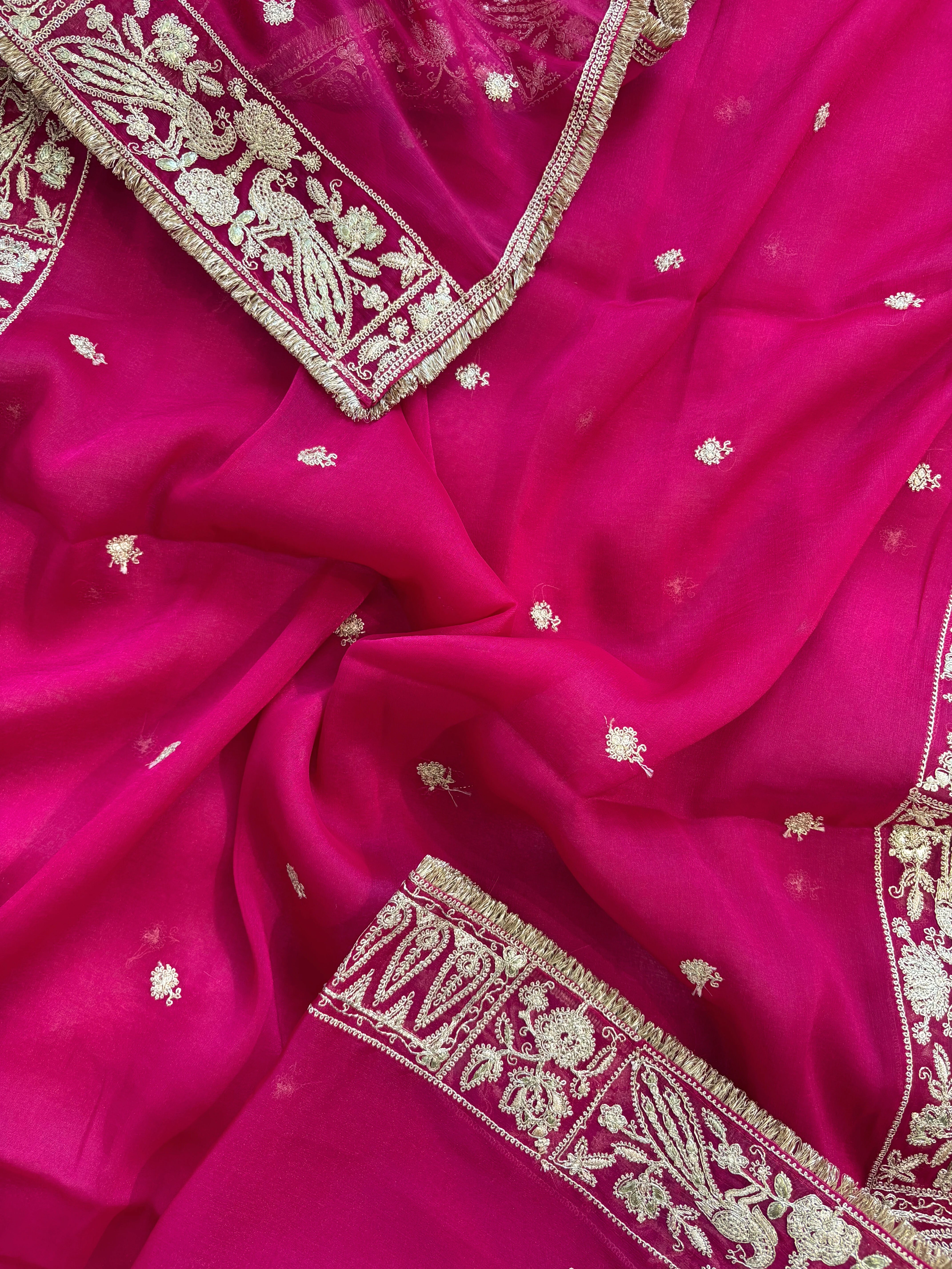 Hot pink organza unstitched suit with golden zari embroidery and embroidered dupatta, ideal for weddings and festive celebrations.