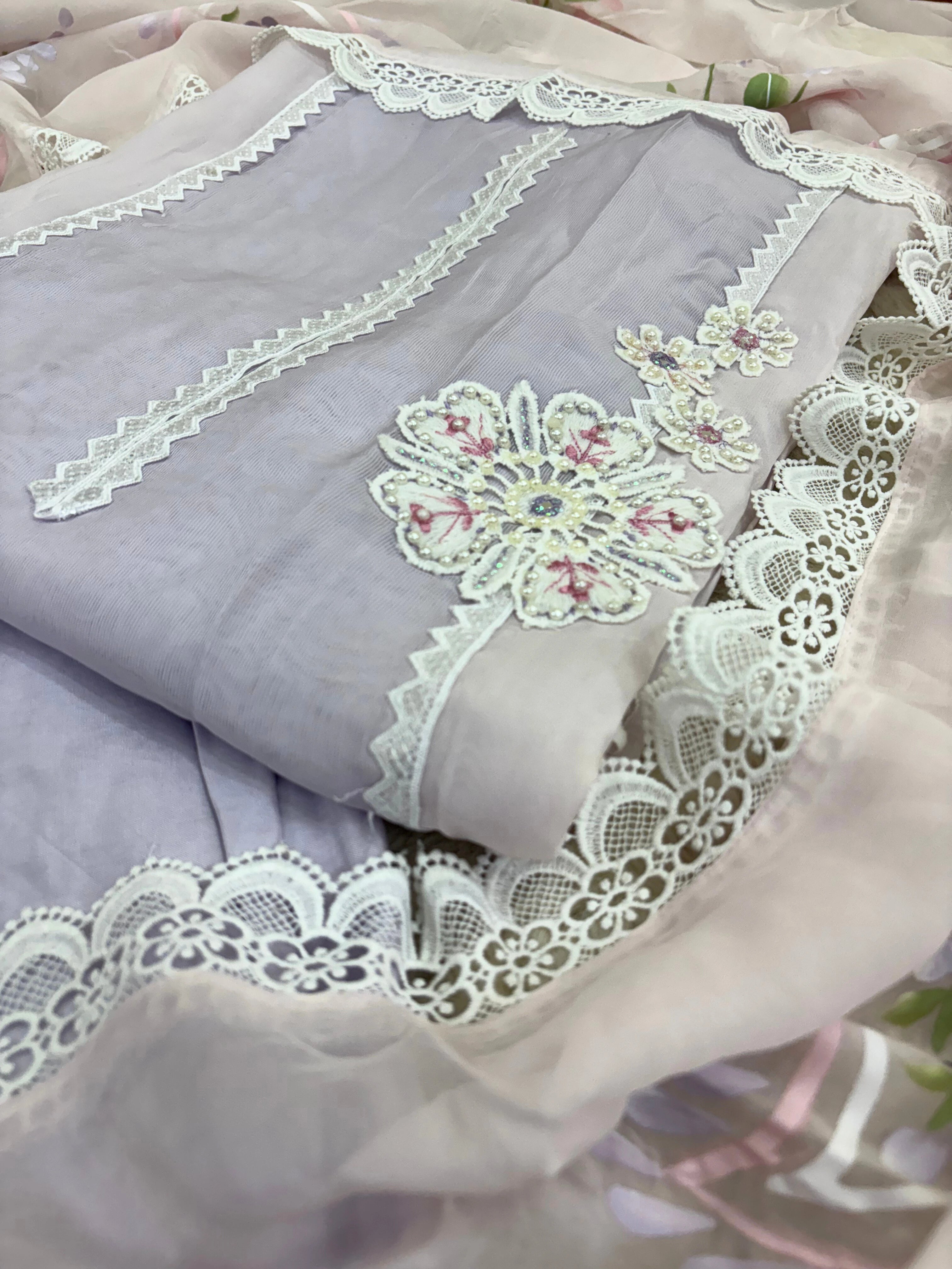 Lavender organza unstitched suit with white lace embroidery, cutwork border, and pastel floral printed organza dupatta – festive summer ethnic wear