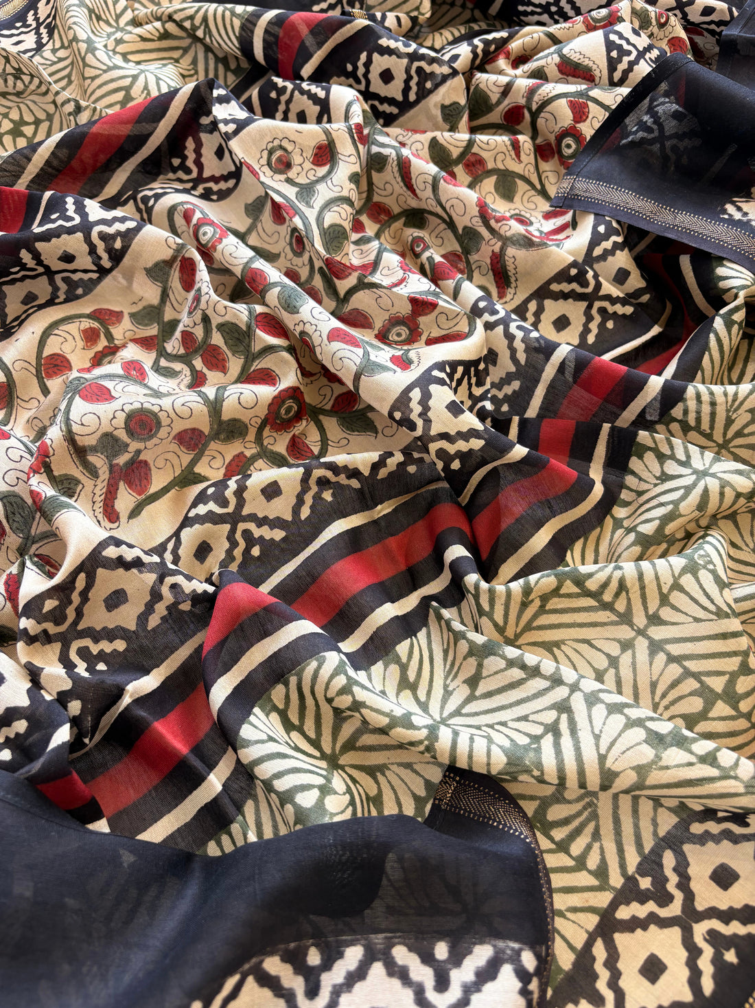 Maheshwari fabric suit with Kalamkari floral print in green, ivory, and maroon tones, featuring traditional hand-block designs and striped dupatta.