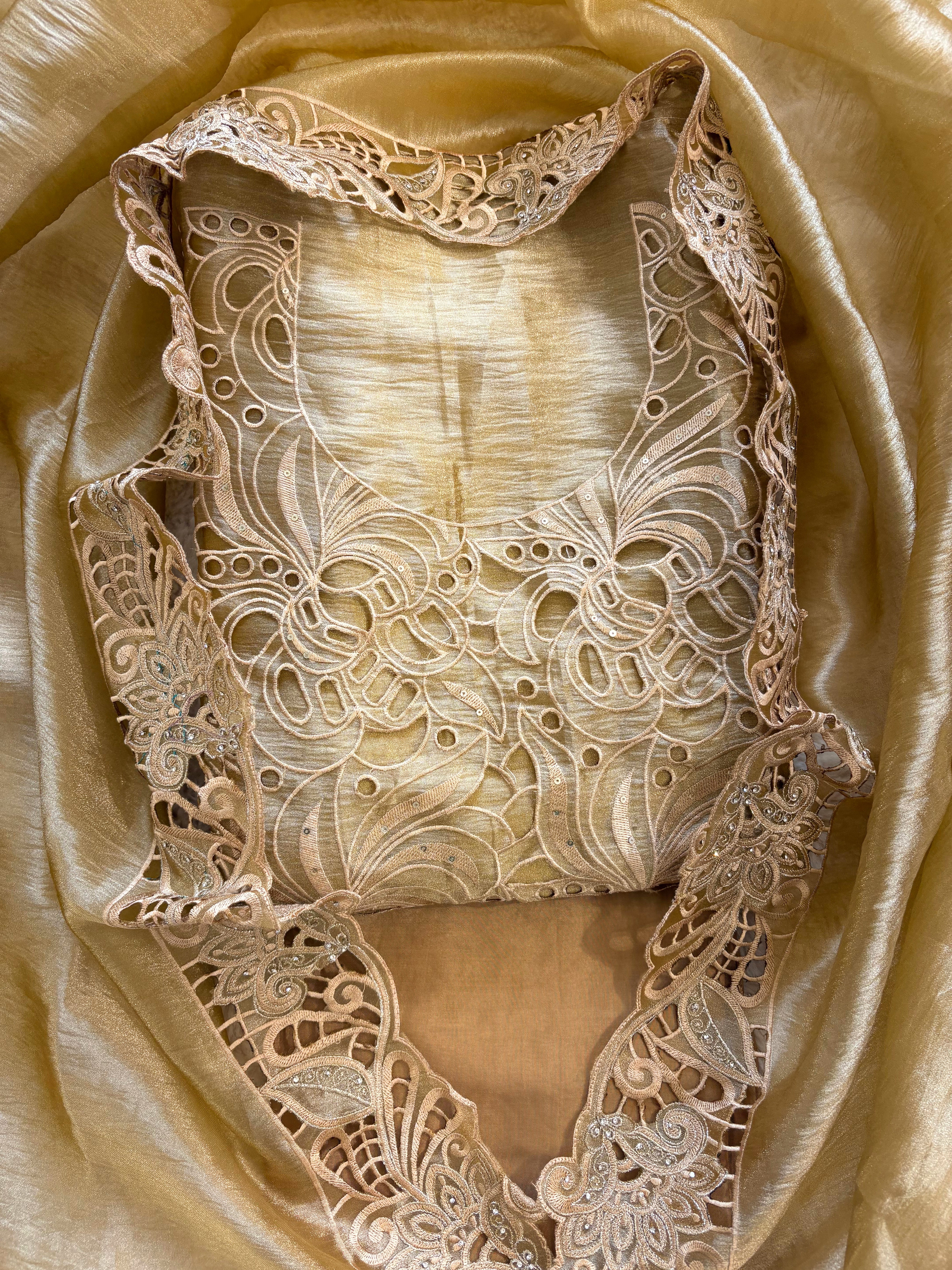 Cutwork detailing along the hemline of gold champagne shimmer tissue suit