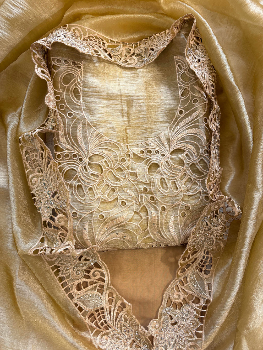 Cutwork detailing along the hemline of gold champagne shimmer tissue suit