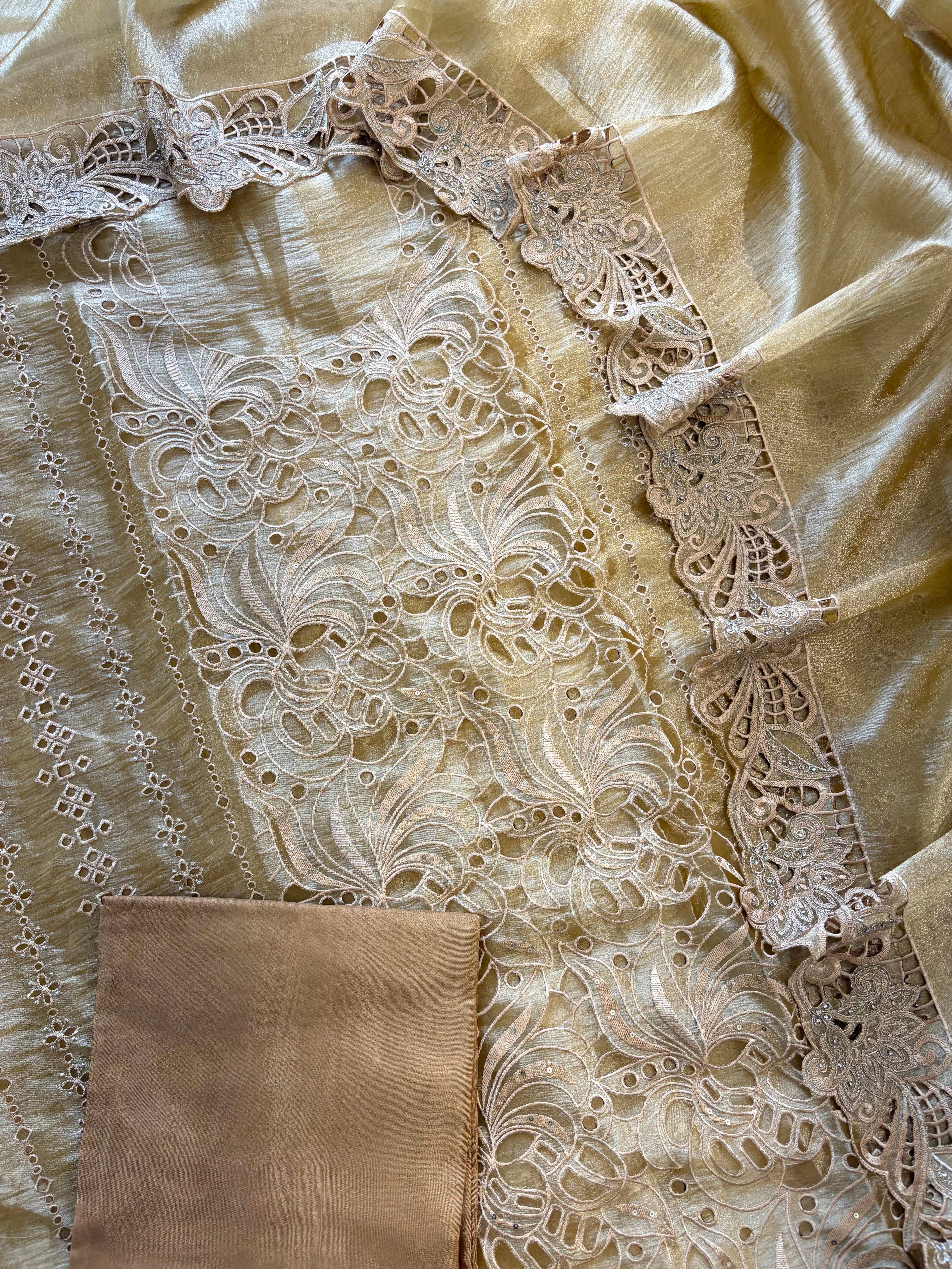 Close-up of cutwork panel at the neckline of gold-champagne-shimmer tissue suit