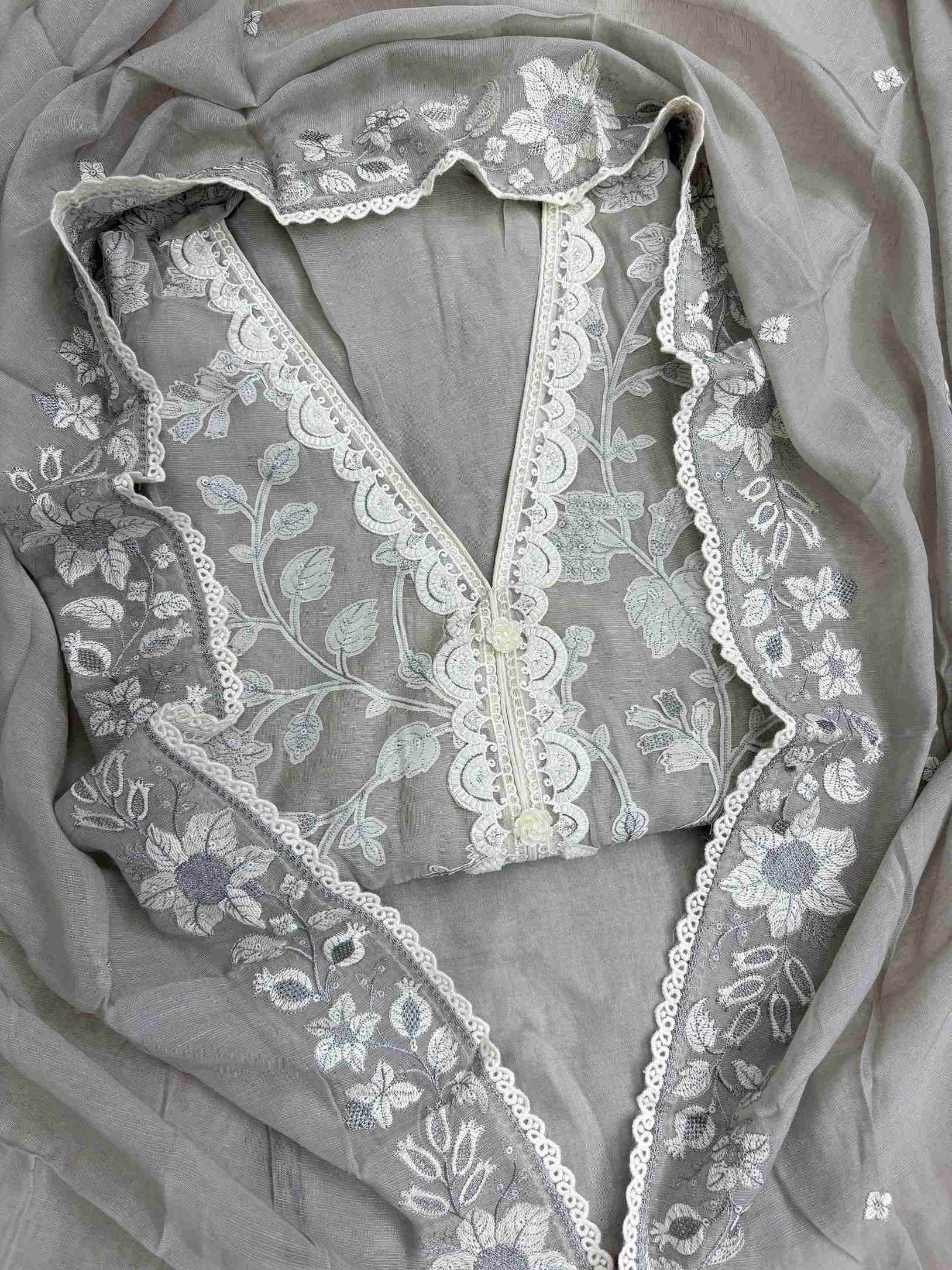 Close-up of monotone kalamkari-style applique work on grey linen shirt