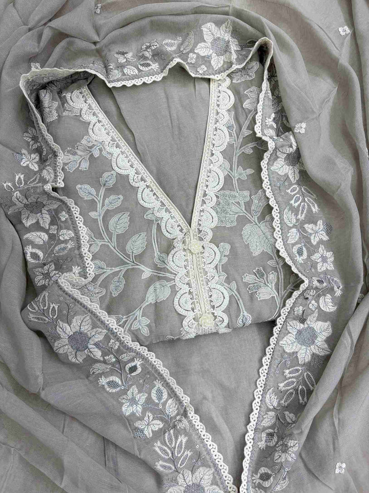 Close-up of monotone kalamkari-style applique work on grey linen shirt