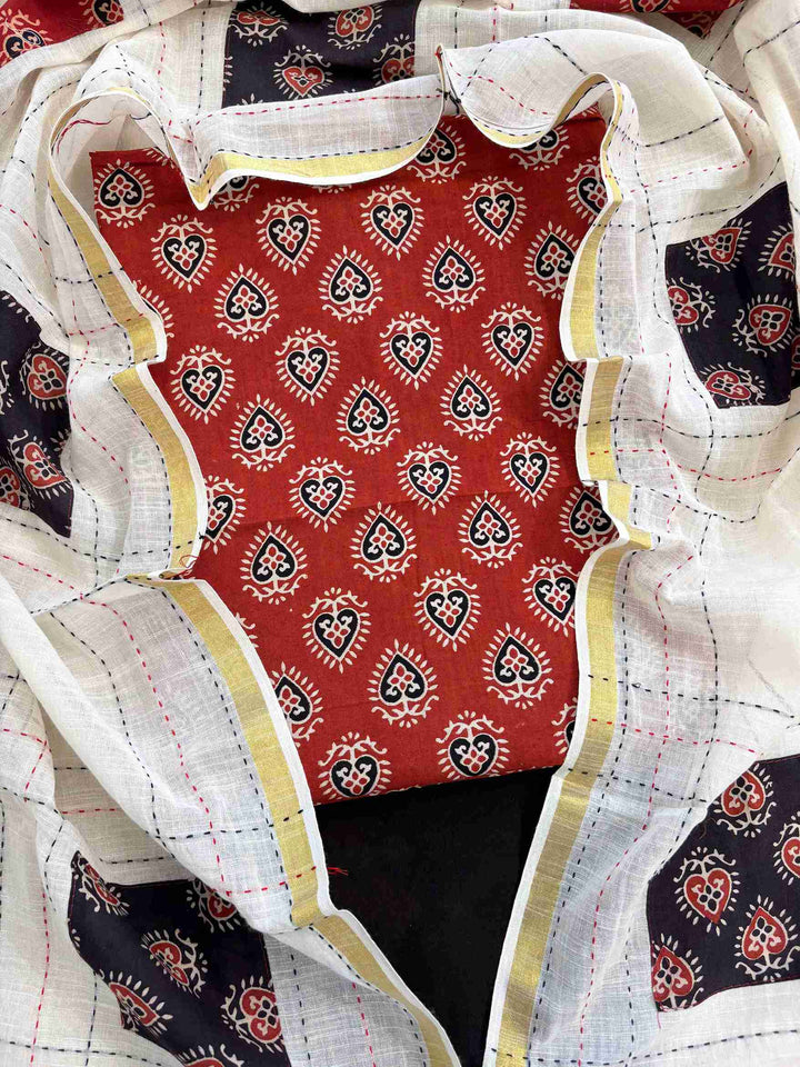 Close-up of rust red handblock printed cotton kurta fabric with ethnic motifs