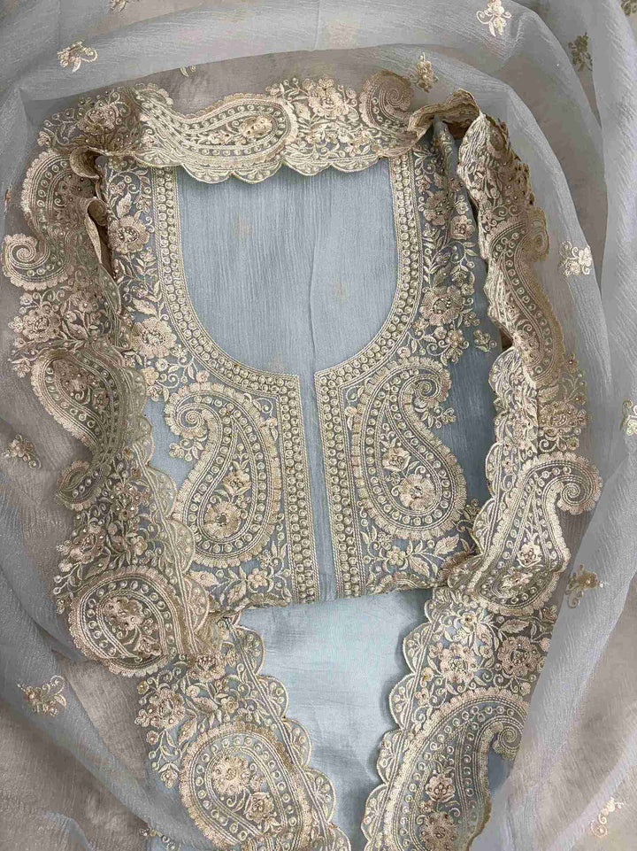Close-up of intricate paisley neckline with cutdana, sequins, and pearl embellishments on ice blue marble chiffon shirt