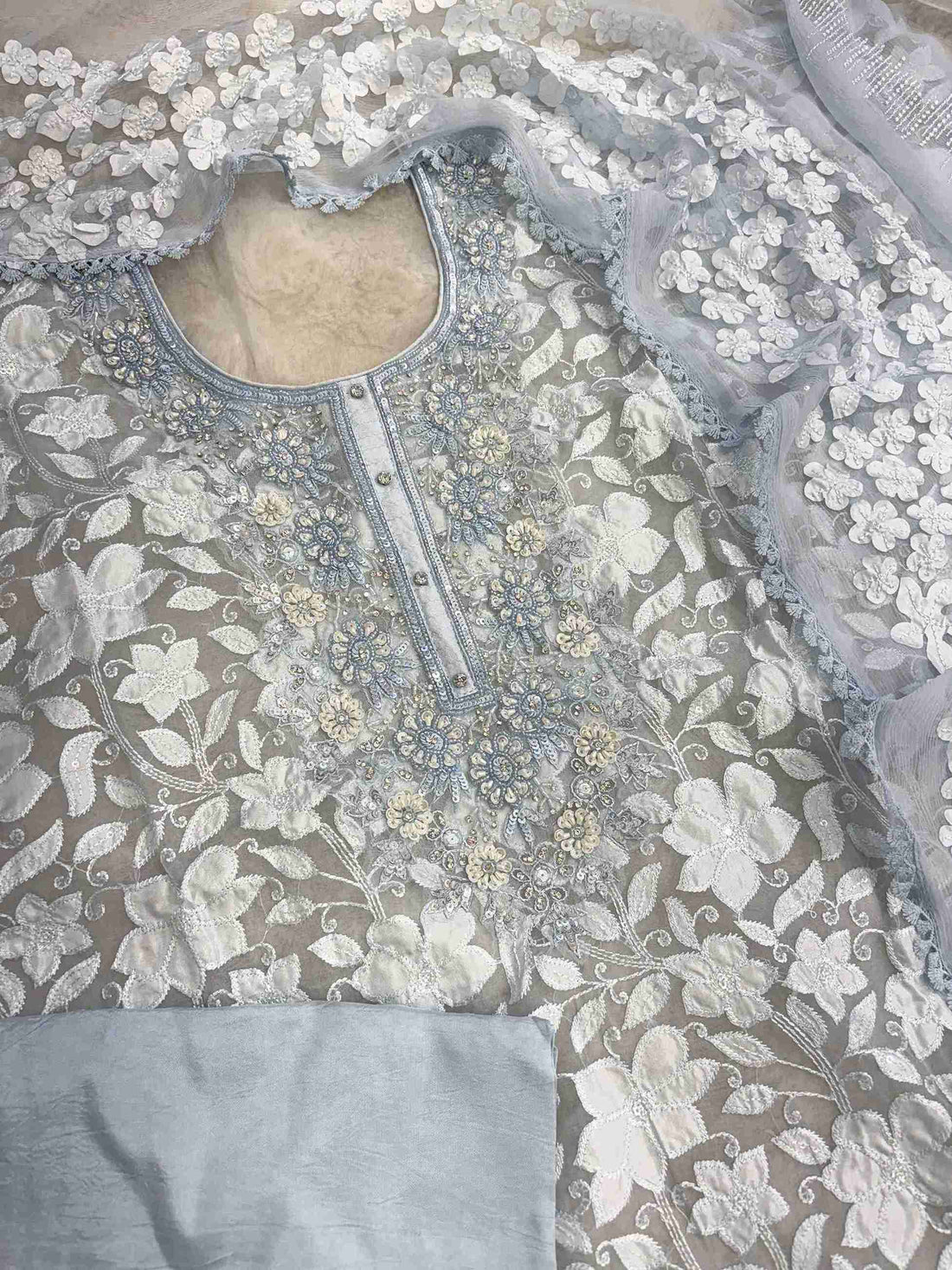 Complete ice blue organza unstitched suit flat lay set with shirt, chiffon dupatta, and opada silk bottom