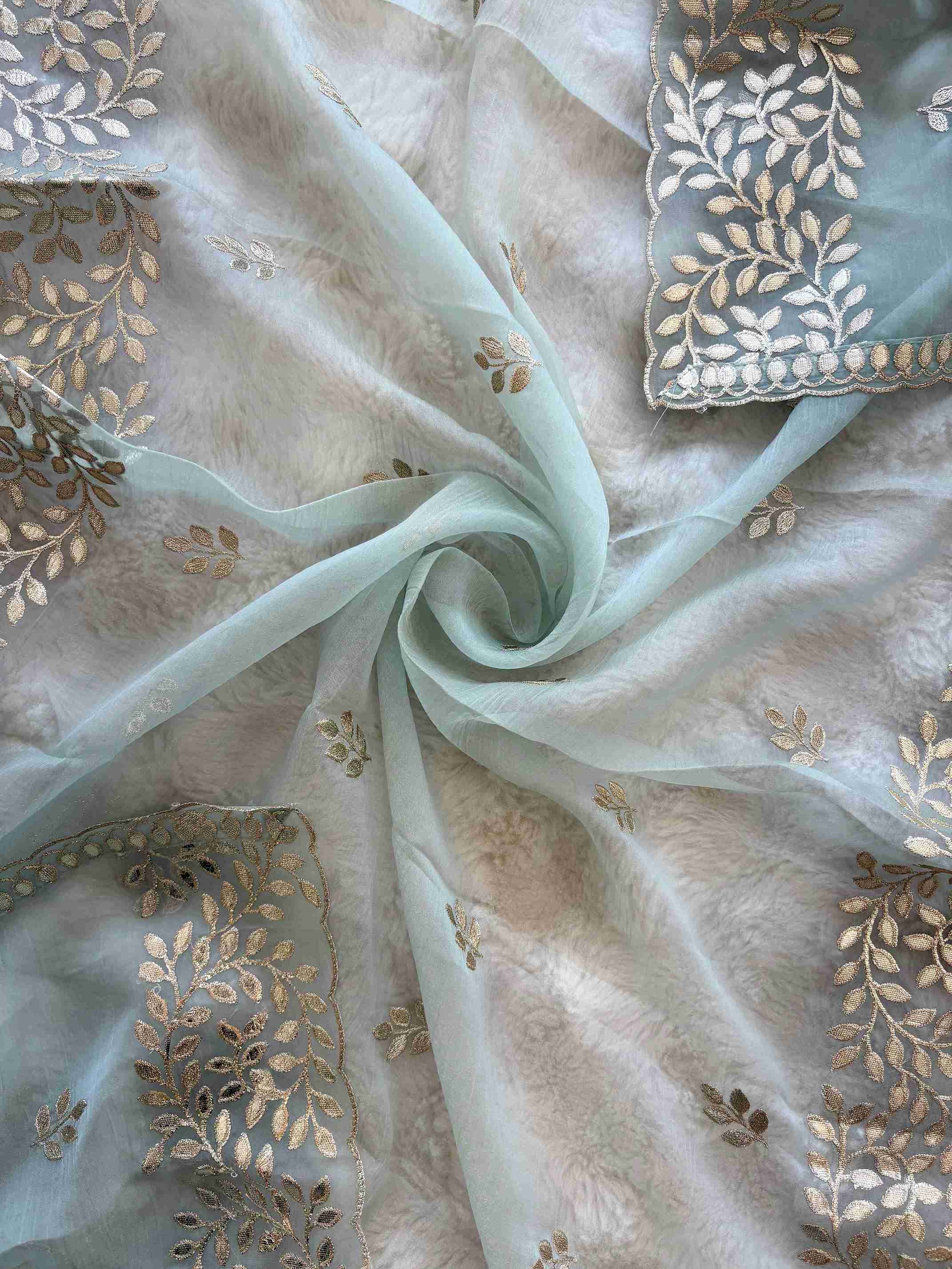 Ice Blue shimmer tissue unstitched suit set flatlay with tissue dupatta and opada silk bottom