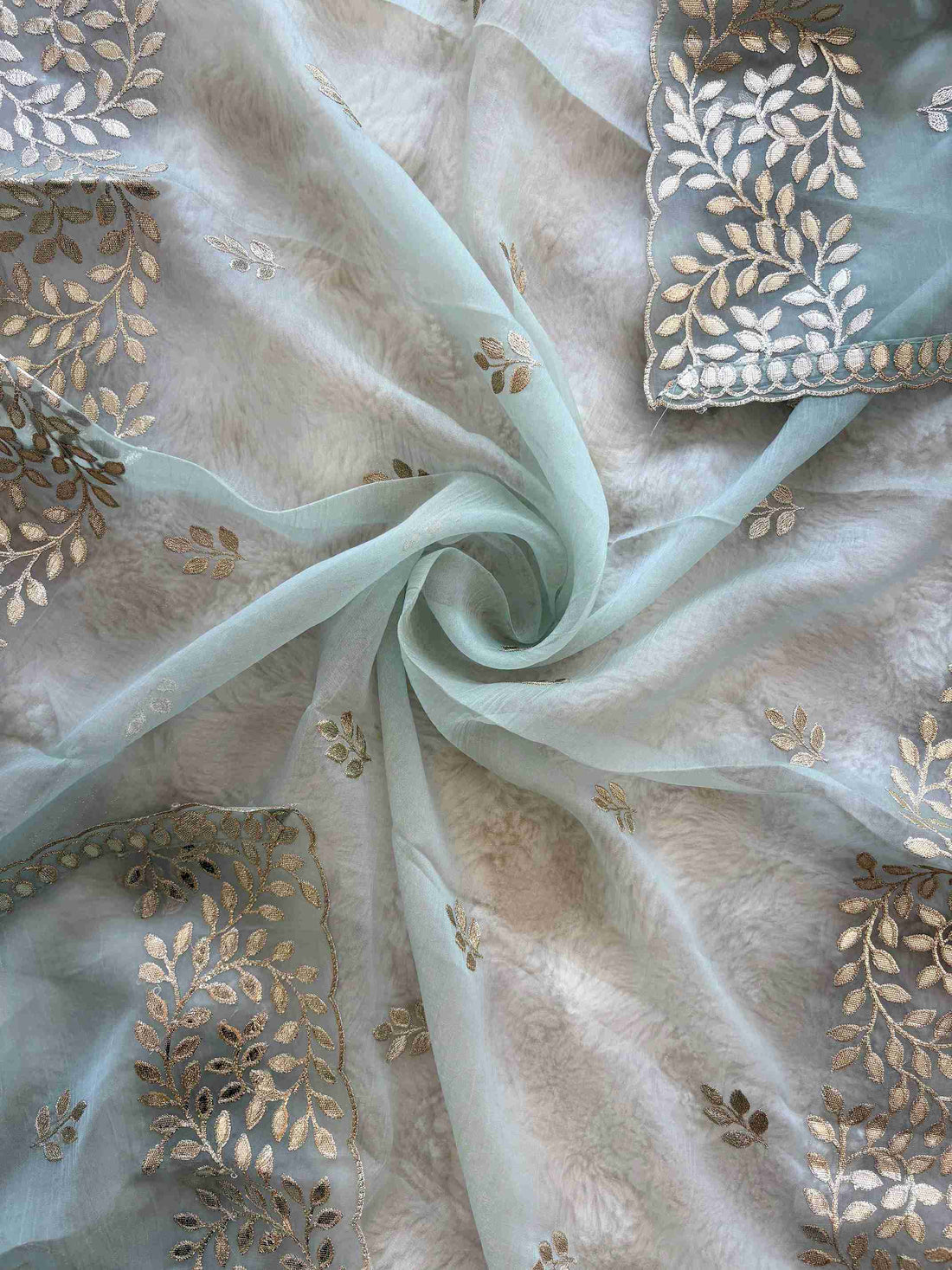Ice Blue shimmer tissue unstitched suit set flatlay with tissue dupatta and opada silk bottom