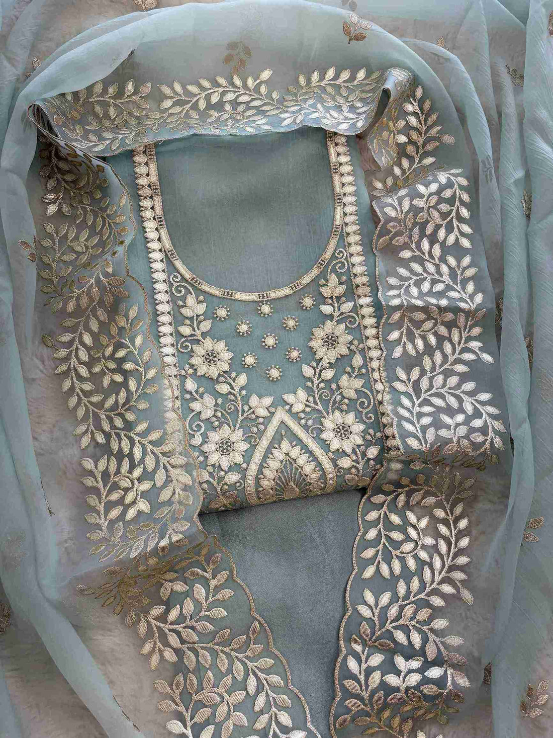 Leather gota border on the hemline of ice blue shimmer tissue suit