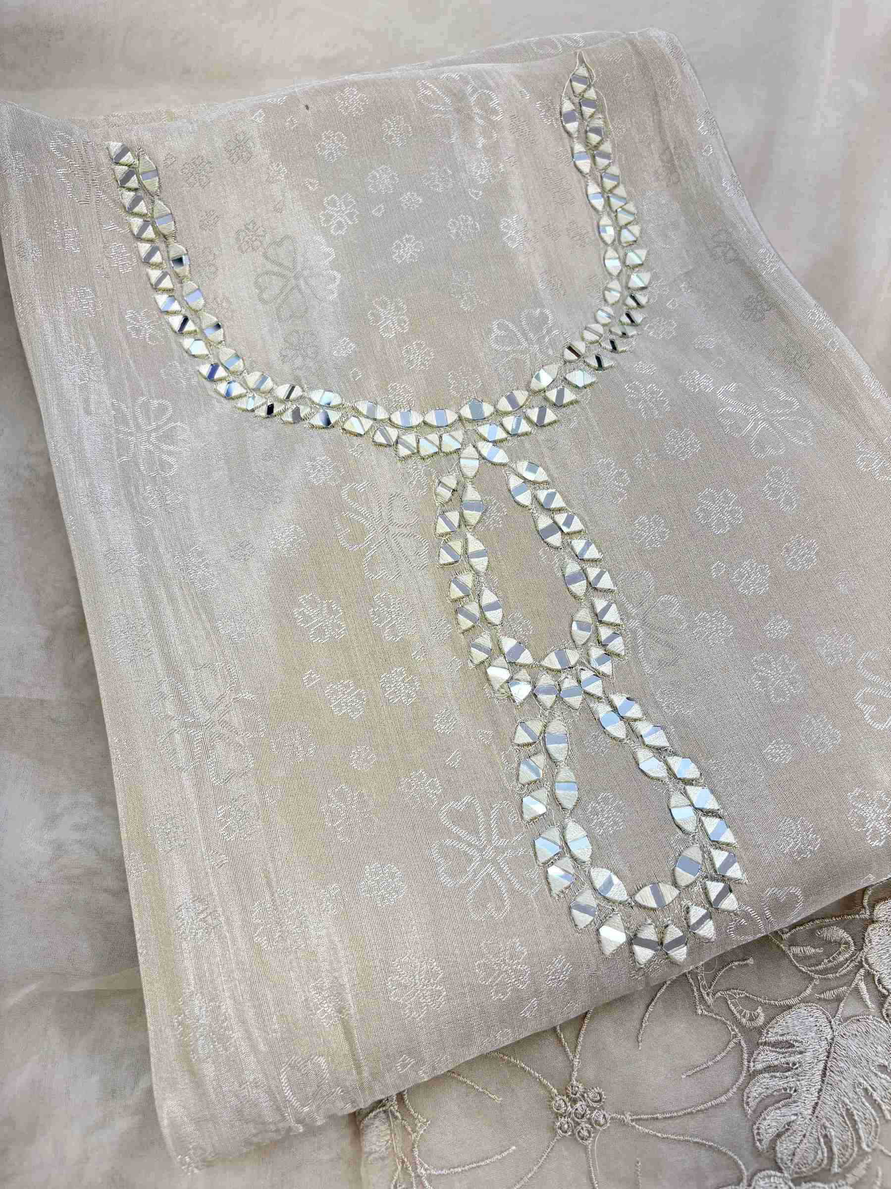 Close-up of mirror work highlighted neckline on ivory Giraffe suit