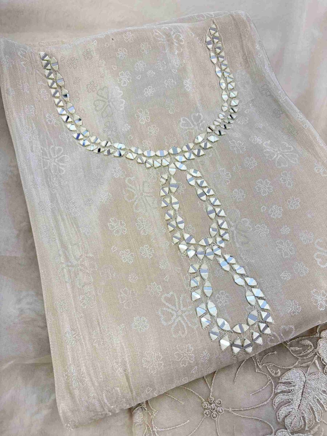 Close-up of mirror work highlighted neckline on ivory Giraffe suit