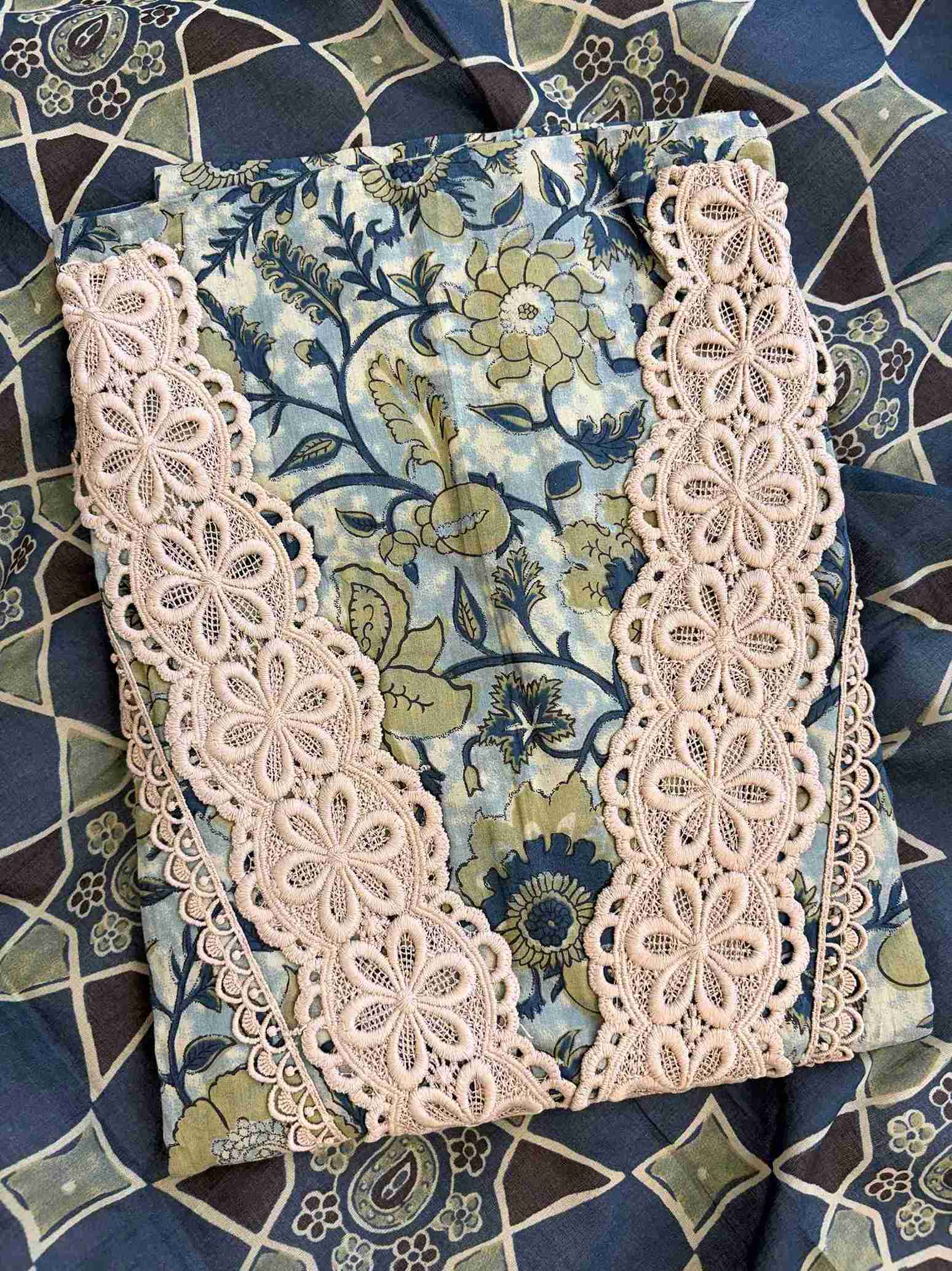 V-shaped neckline with broad crotia lace highlighting and decorative bead and coin tassels on jade green cotton shirt