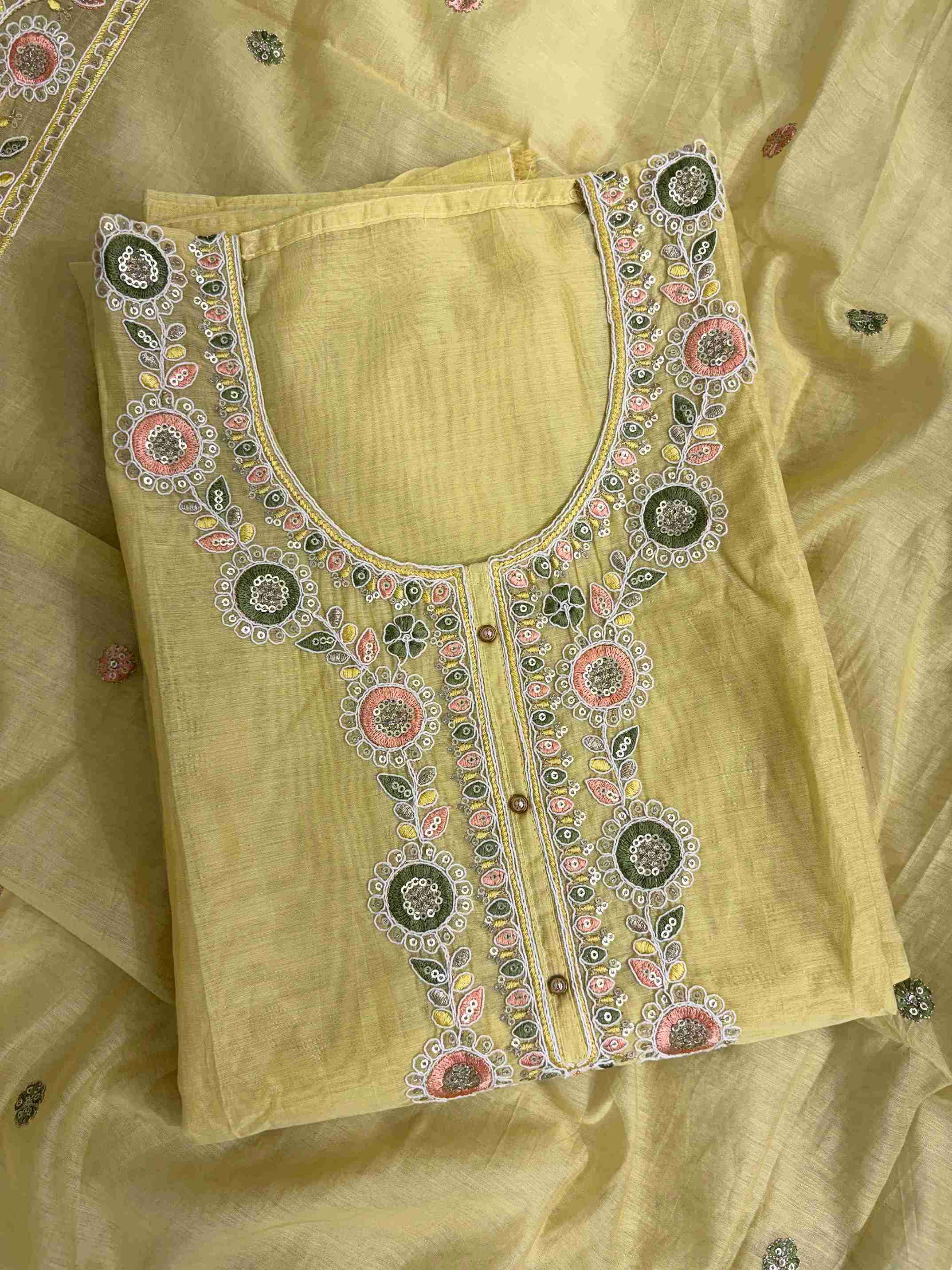 Multicolor thread embroidered floral motifs with mirror work at neckline and front placket of lemon yellow mul chanderi shirt