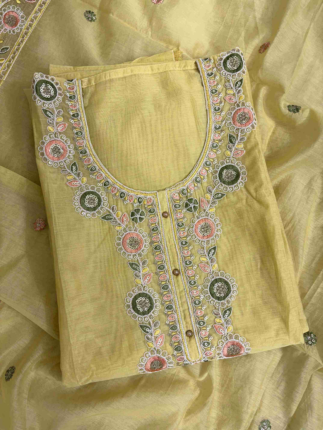 Multicolor thread embroidered floral motifs with mirror work at neckline and front placket of lemon yellow mul chanderi shirt