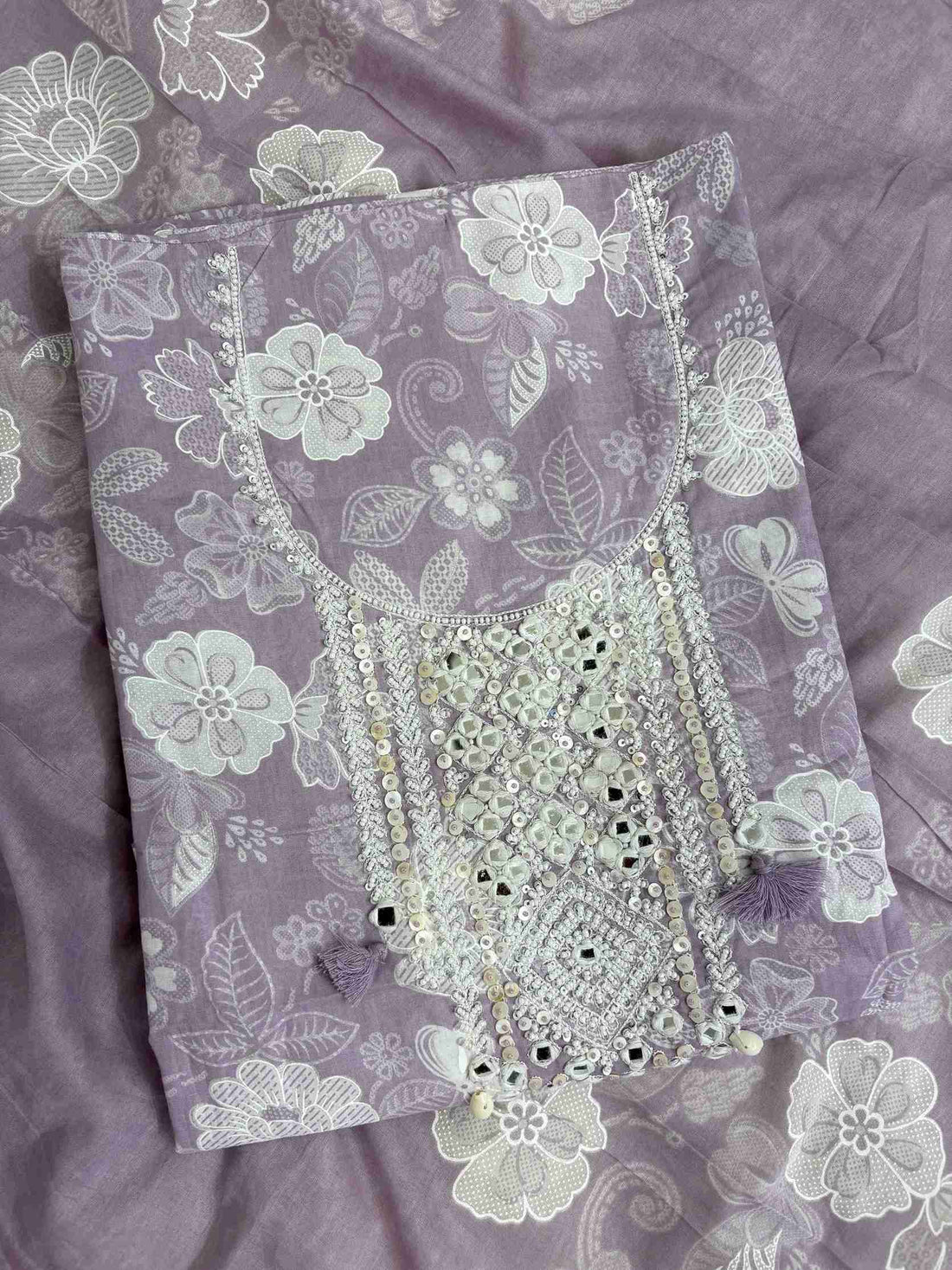 Close-up of mirror work, sequin and moti embellished neckline panel with tassels on lilac cotton shirt