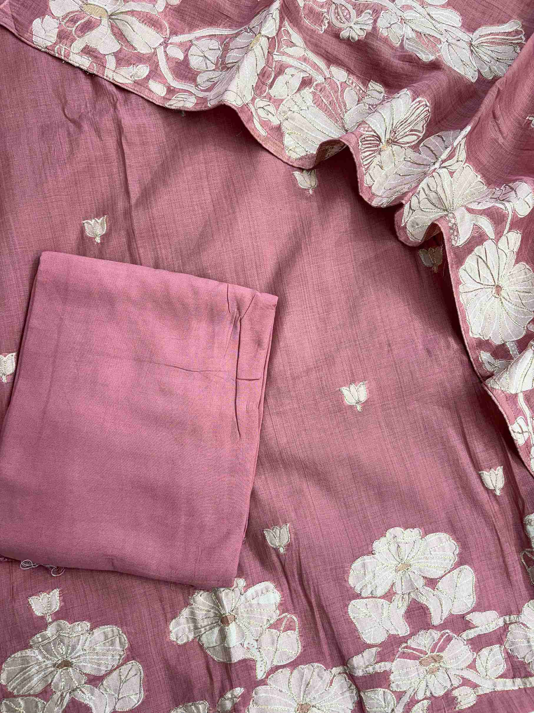 mauve pink suit showcasing delicate woven floral booties across the fabric