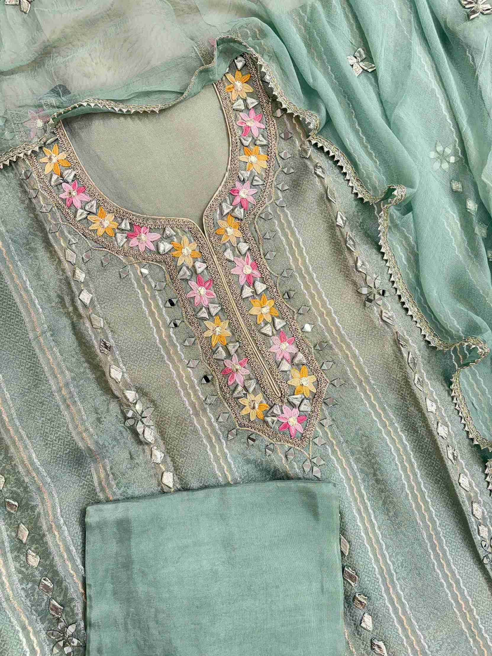 Complete mint green shimmer tissue unstitched suit flat lay set with shirt, chiffon dupatta, and opada silk bottom