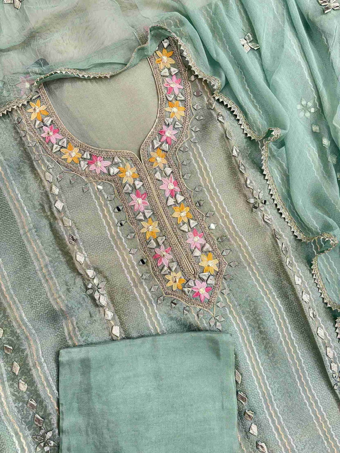 Complete mint green shimmer tissue unstitched suit flat lay set with shirt, chiffon dupatta, and opada silk bottom
