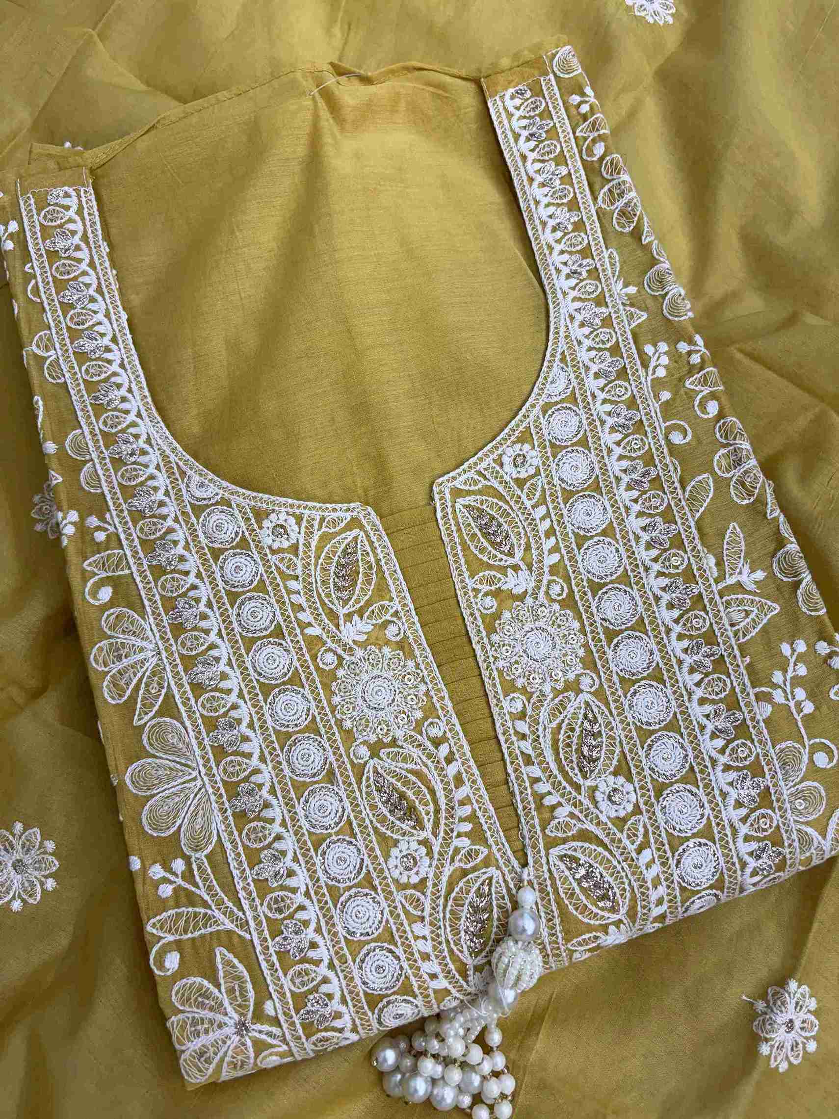 Close-up of U neckline with deep V cut and tassels on mustard embroidered suit