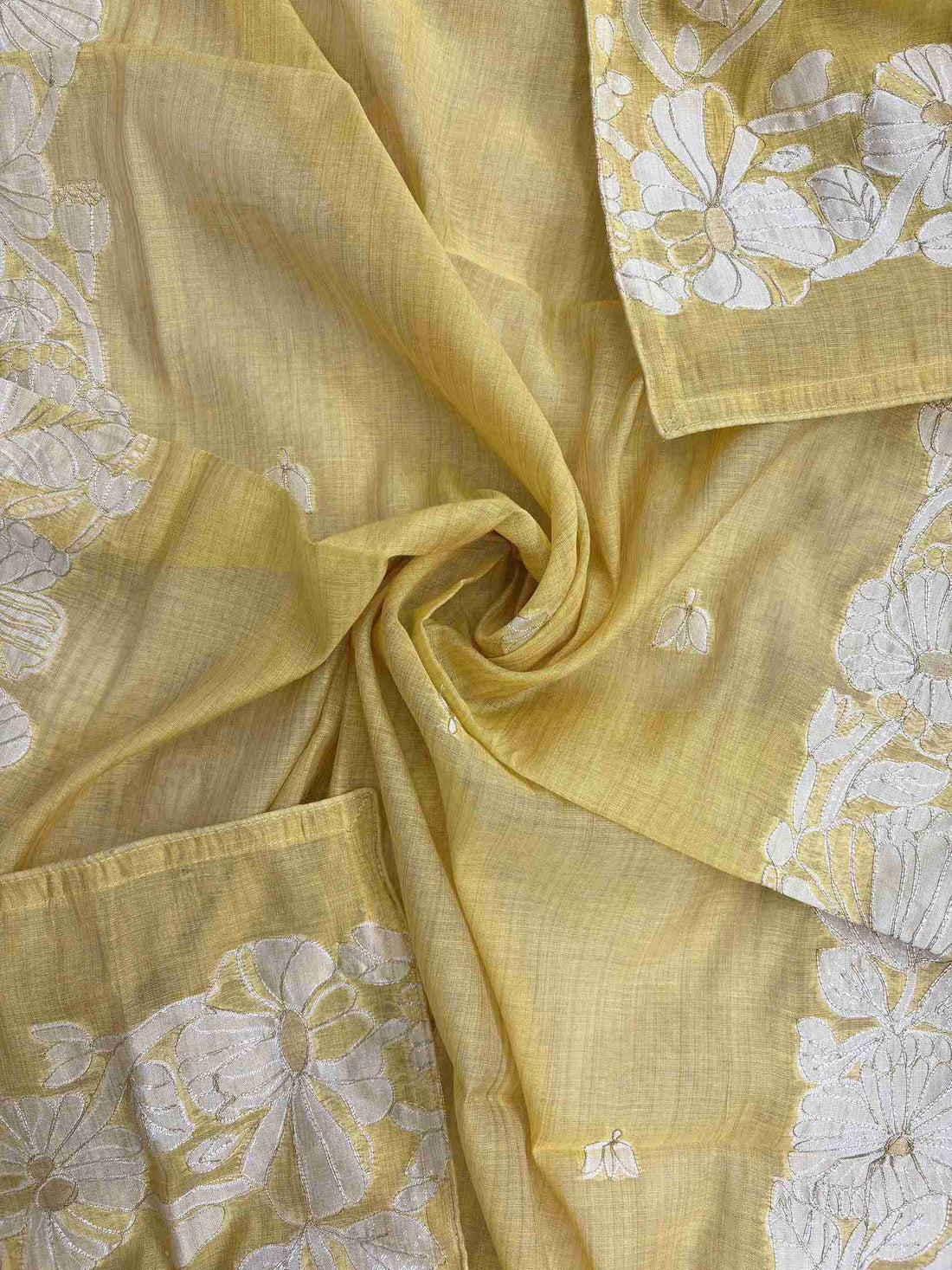 Mustard suit showcasing delicate woven floral booties across the fabric