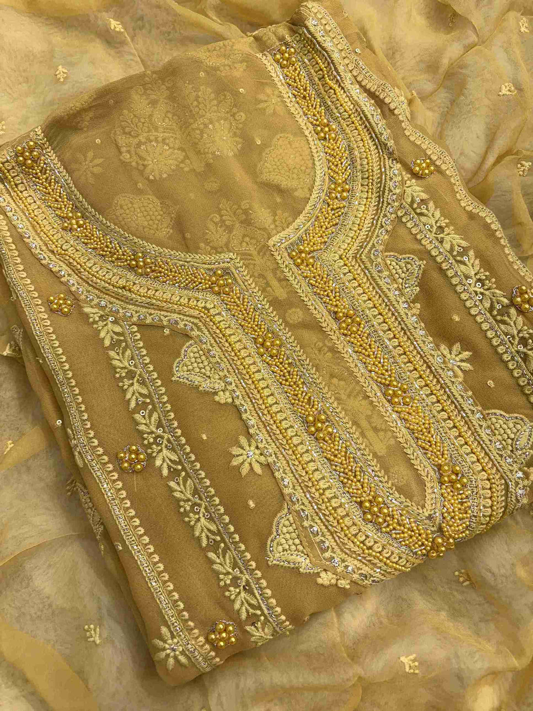 Close-up of mustard georgette shirt featuring intricate hand embroidery with beads and sequins work