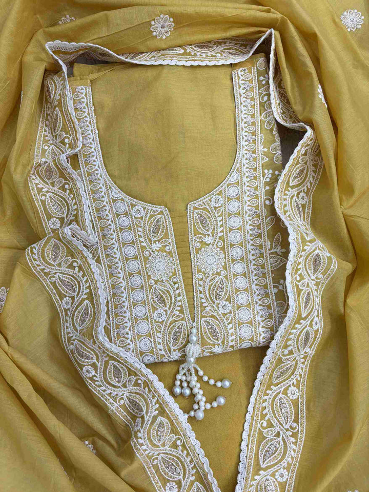 Mustard mul chanderi suit with white resham embroidery and tassel neckline front view